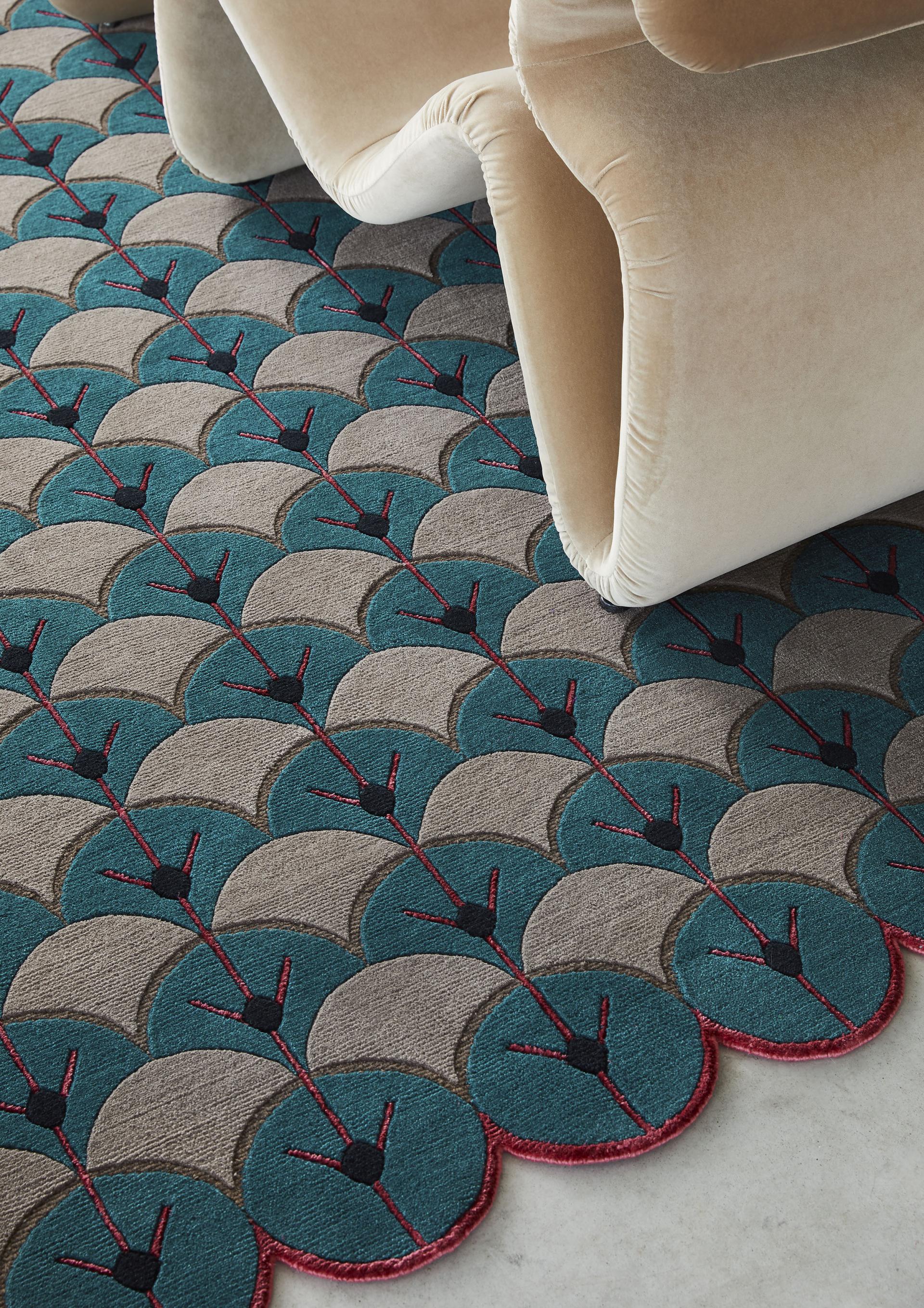 Elegant velvet chair placed on a patterned rug featuring teal, gray, and red designs, showcasing unique style influences.