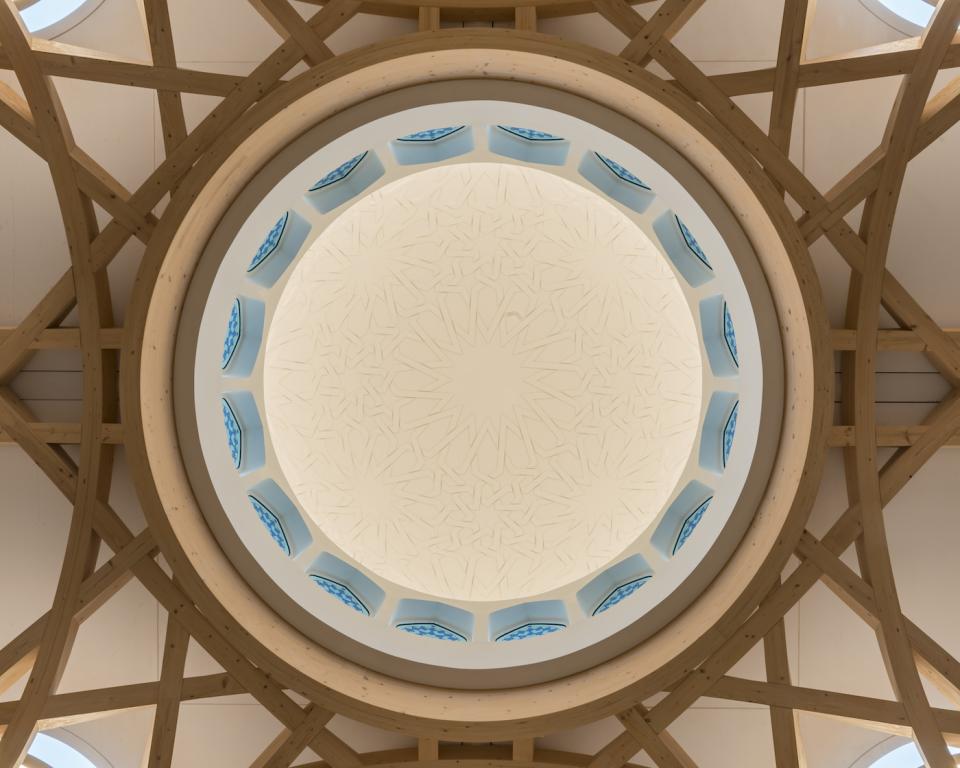 Aerial view of the intricate dome and wooden framework of Cambridge Central Mosque, highlighting its sustainable architecture and design.