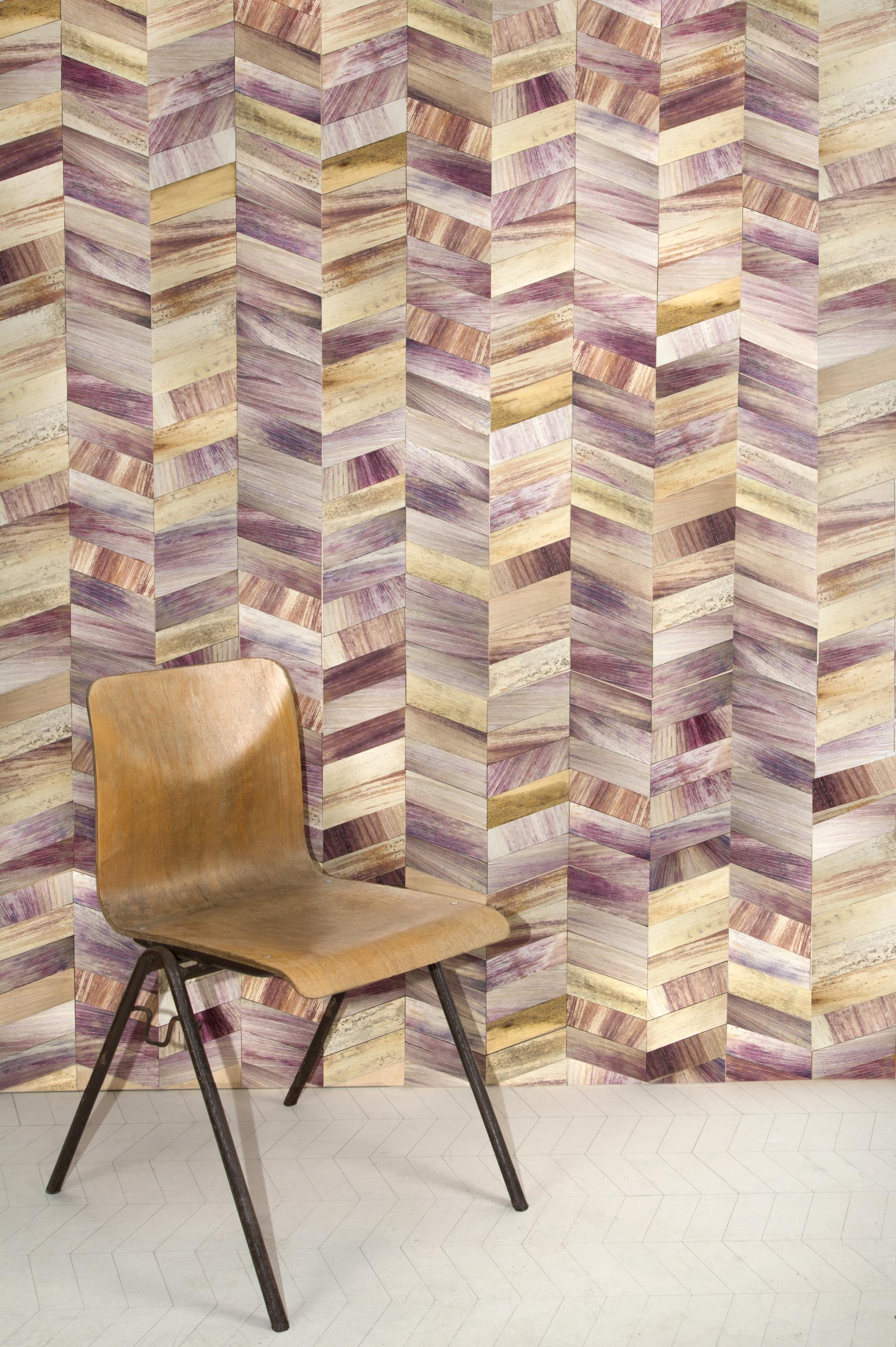 Chair in front of vibrant, multicolored Totomoxtle wall, showcasing sustainable design and natural aesthetics.