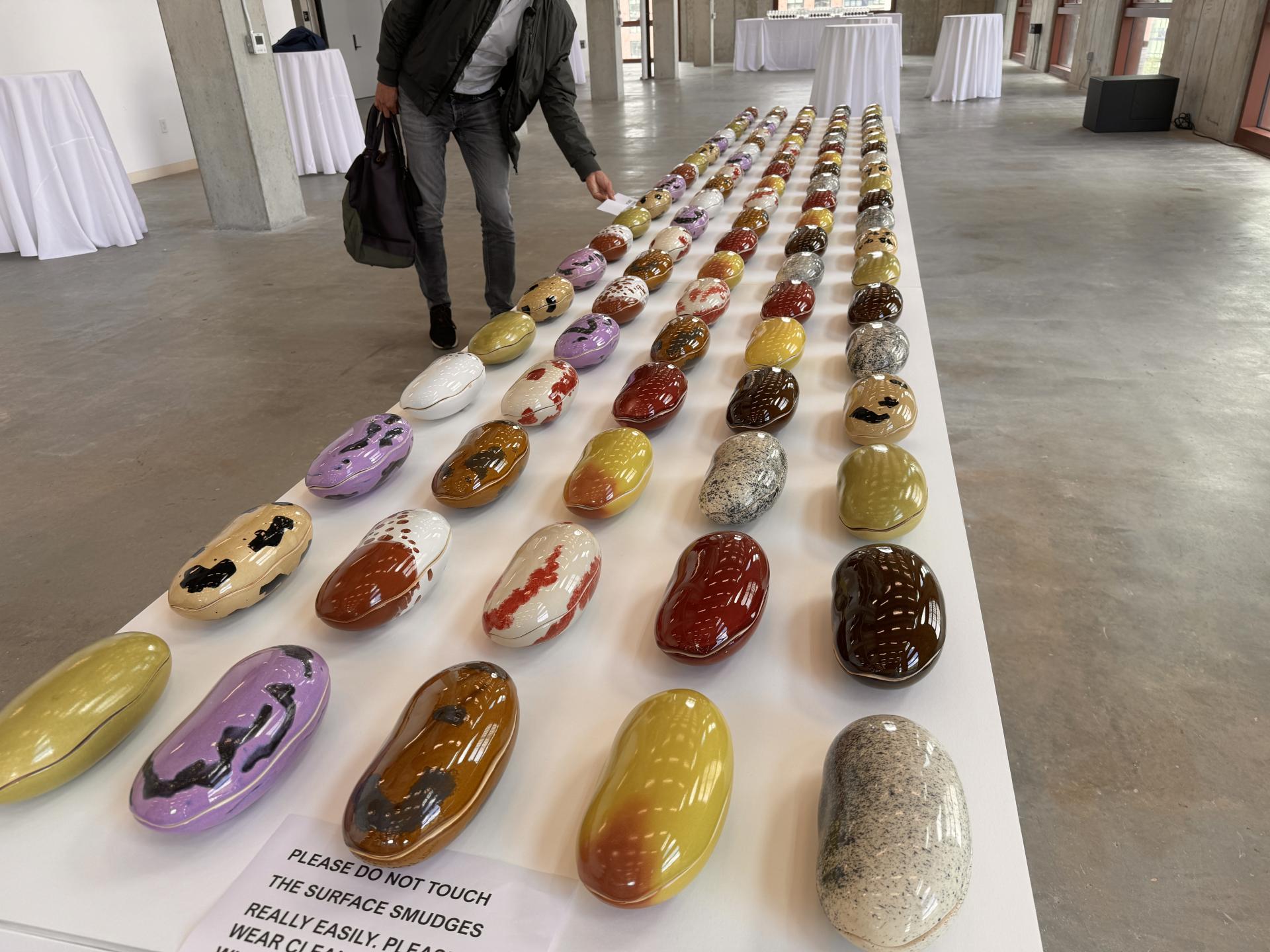 Colorful, ceramic bean-shaped objects displayed at Dutch Design Week 2024, showcasing innovative design and craft techniques.