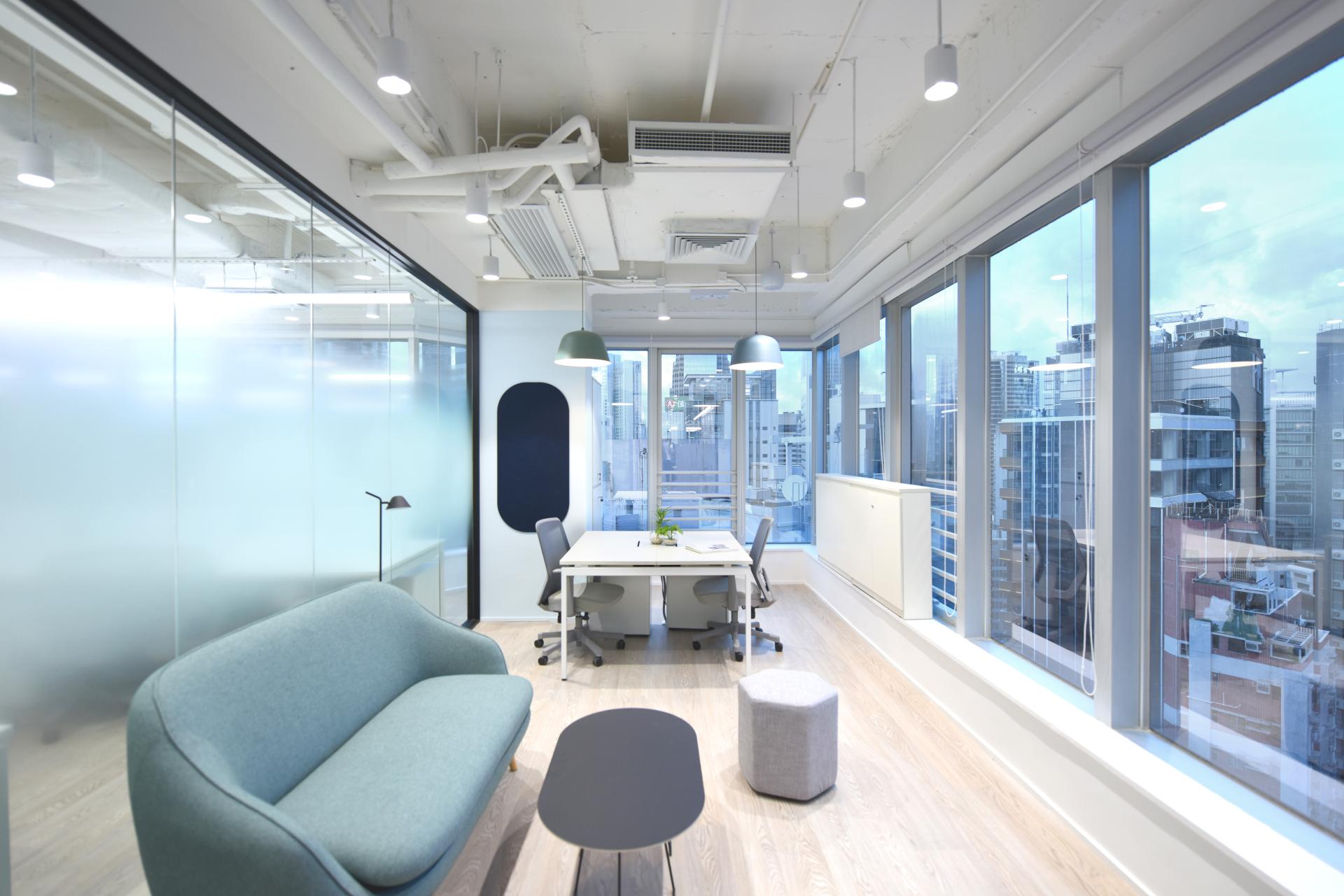 Modern office space designed for a travel technology company, featuring large windows, contemporary furniture, and urban views.