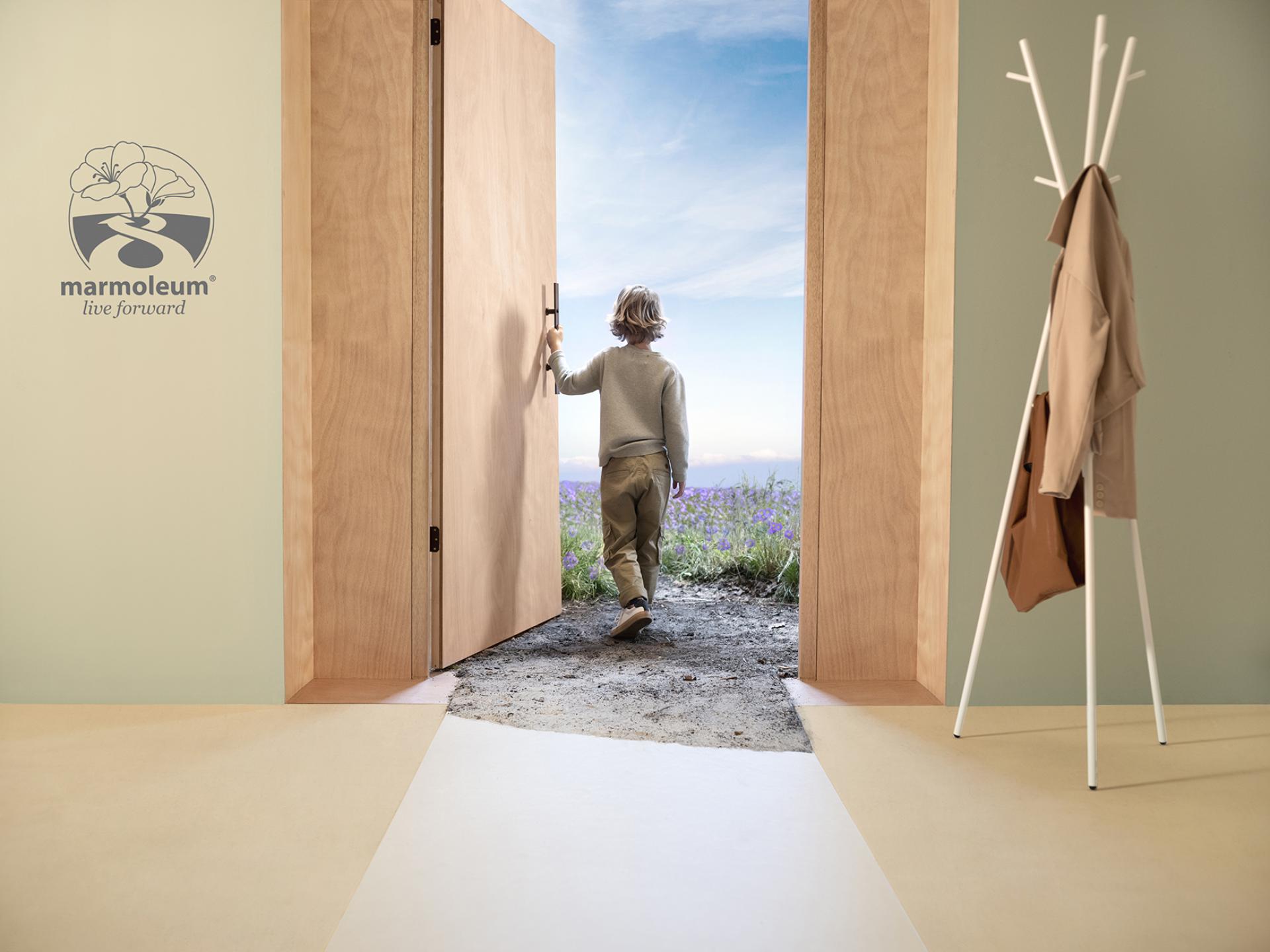 A child opens a wooden door, stepping into a bright outdoor landscape adorned with flowers, symbolizing sustainability and fresh perspectives.