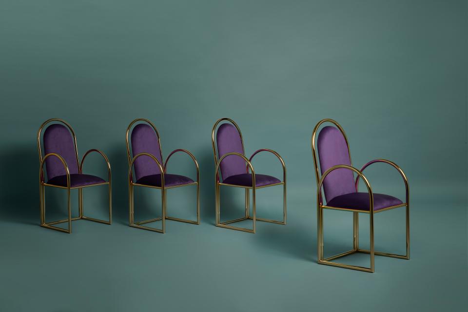 Vintage-inspired purple chairs with gold metal frames, designed by Masquespacio and Houtique, set against a teal background.