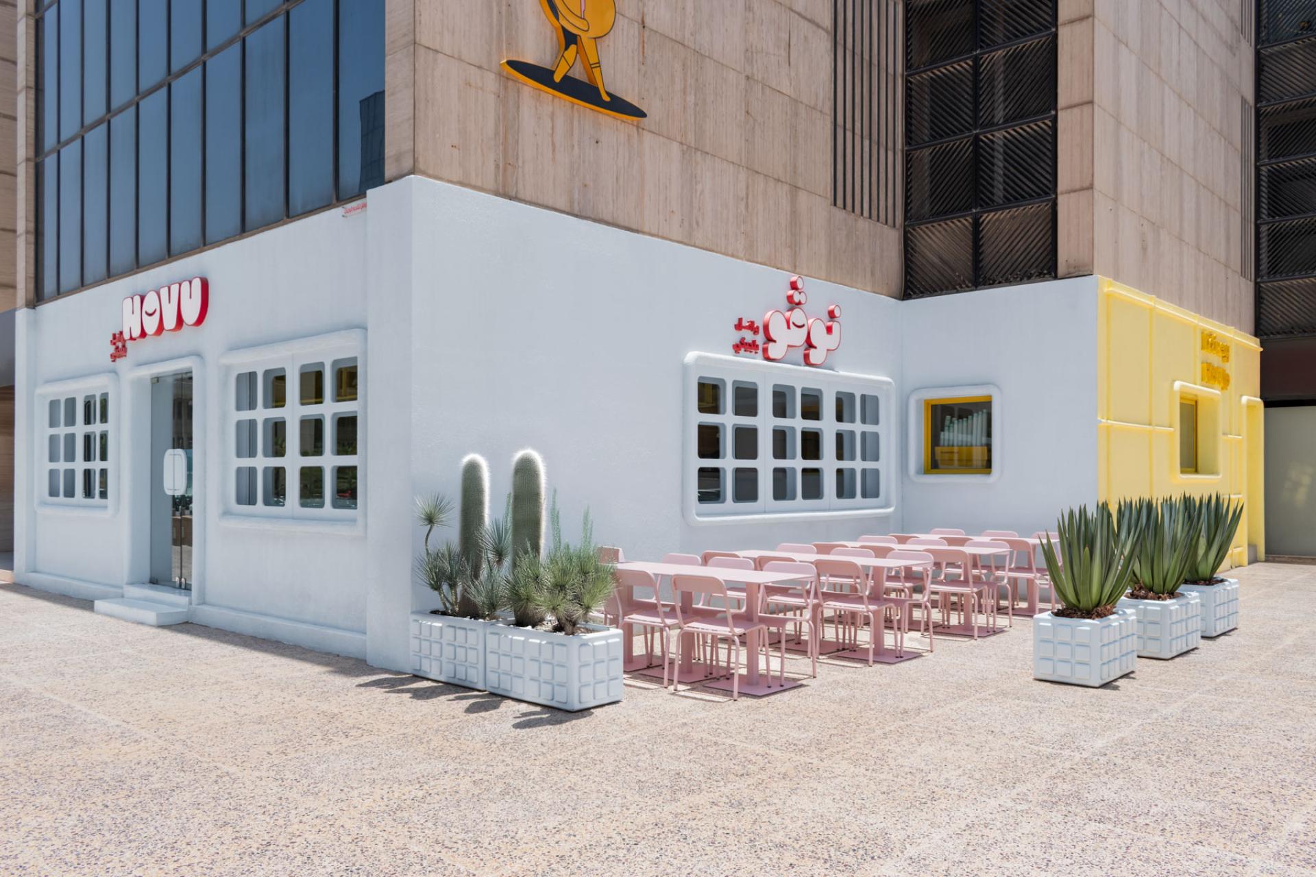 Futuristic Novu Waffle restaurant featuring modern architecture, vibrant colors, and an outdoor dining area in a stylish setting.