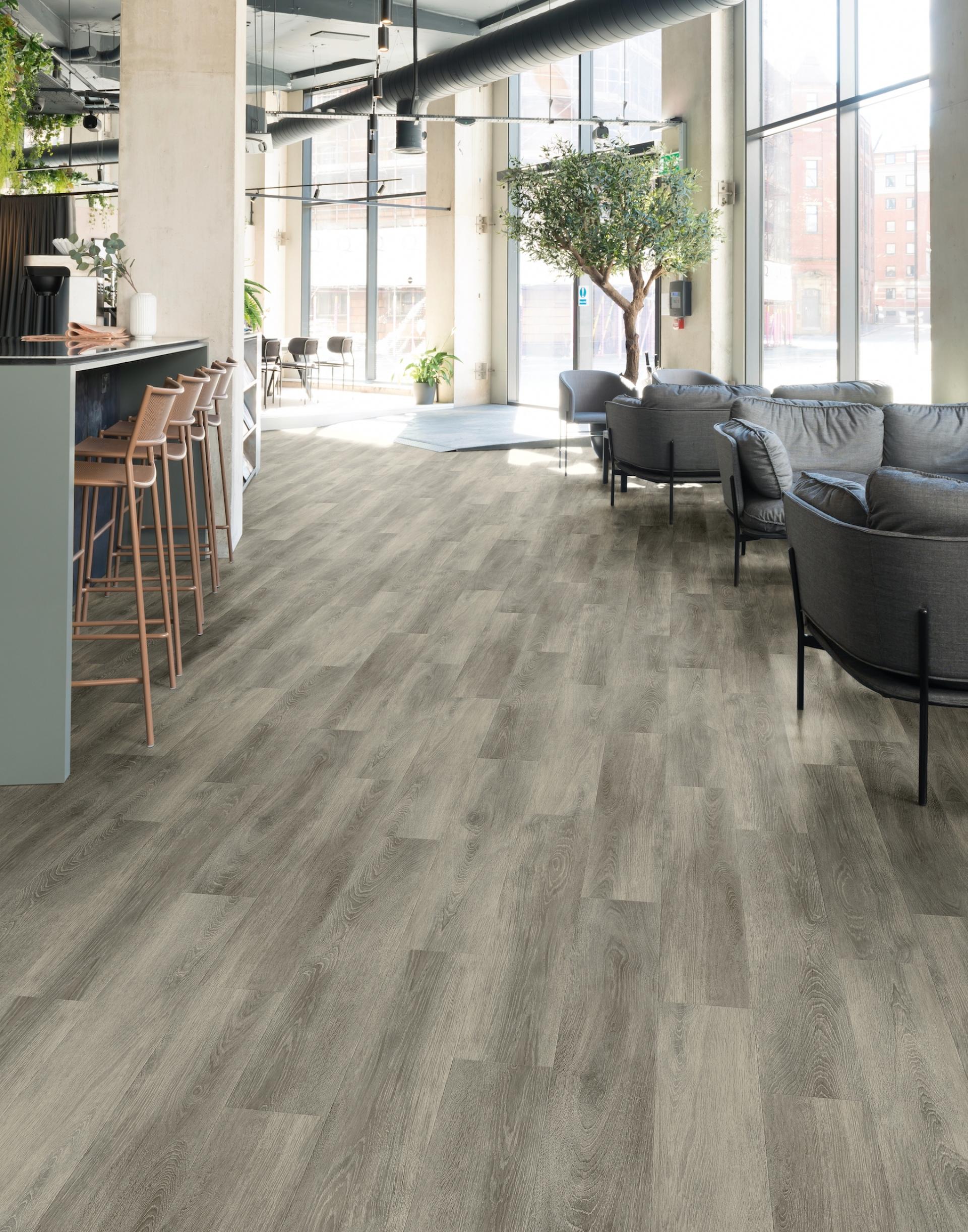 Spacious interior featuring Amtico Bio lower carbon flooring, enhancing the modern design with natural light and greenery.