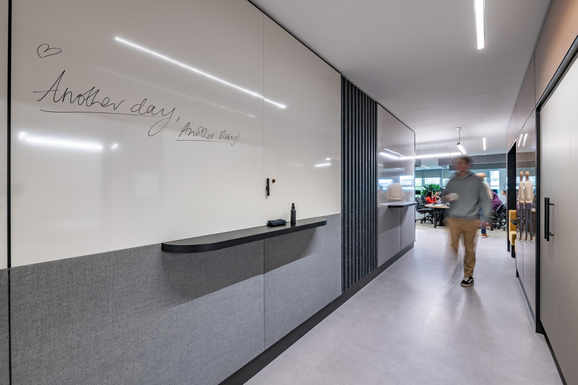 Modern office hallway featuring a motivational message on a whiteboard, reflecting innovative workspace design for FinTech.