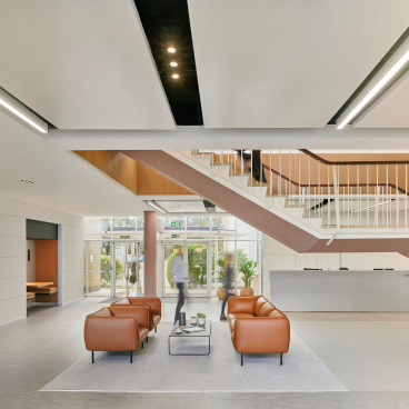 Modern interior of the Manchester International Office Centre featuring stylish seating, a staircase, and abundant natural light.