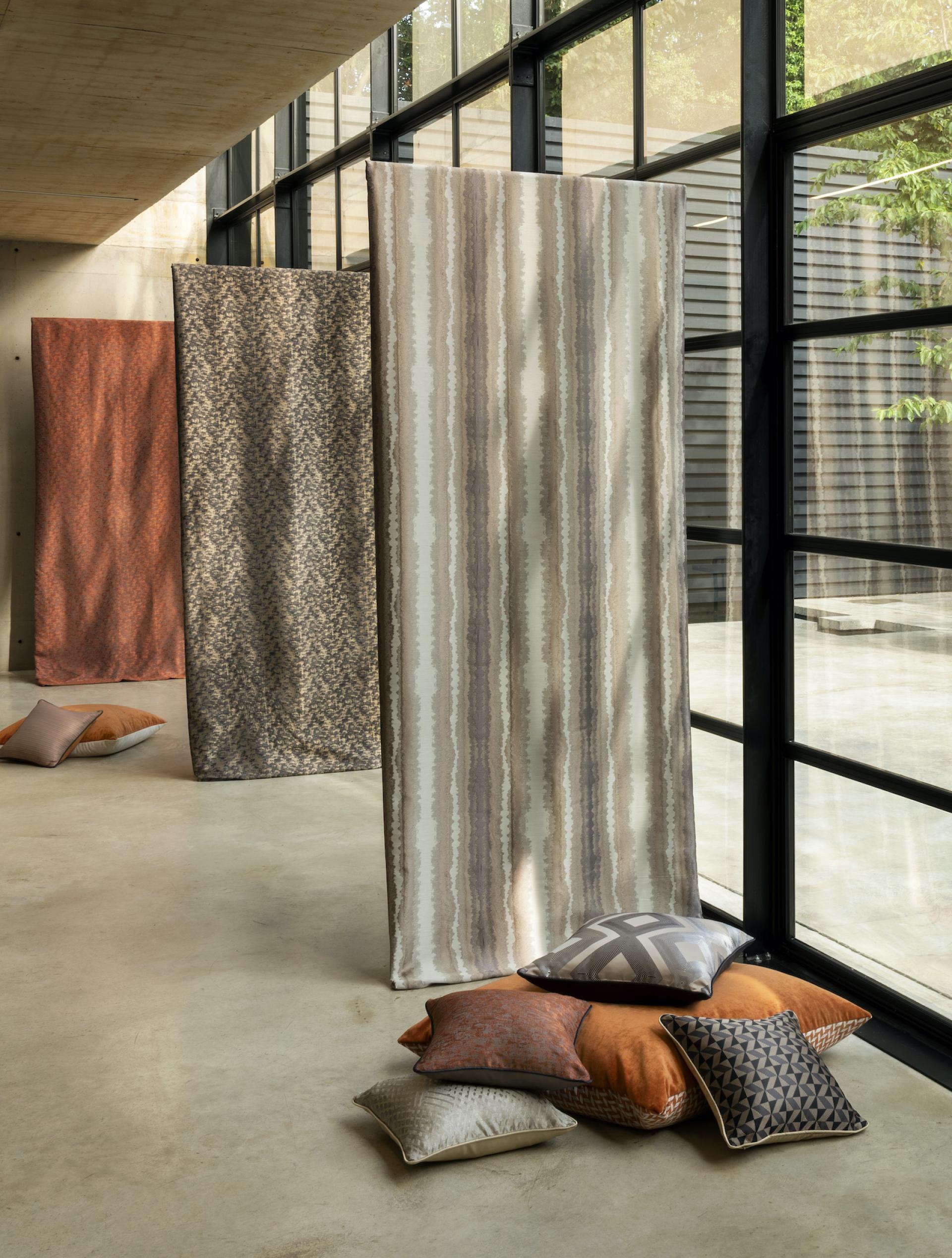 Decorative fabrics and stylish cushions arranged in a modern interior space, highlighting Panaz's innovative design for hospitality.