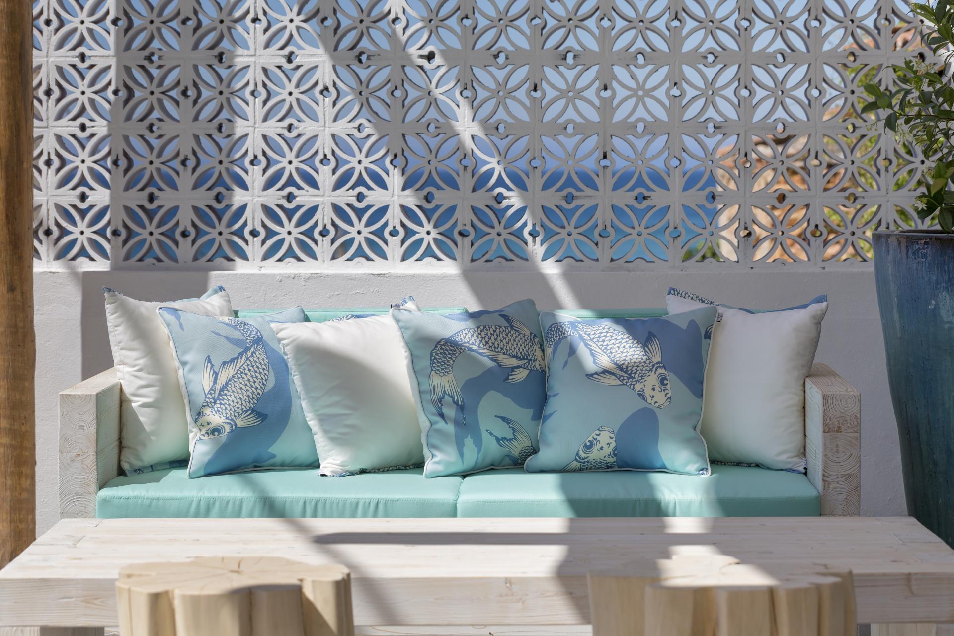 Stylish seating area with patterned pillows, showcasing sustainable design inspired by Portuguese aesthetics in JSH Algarve.