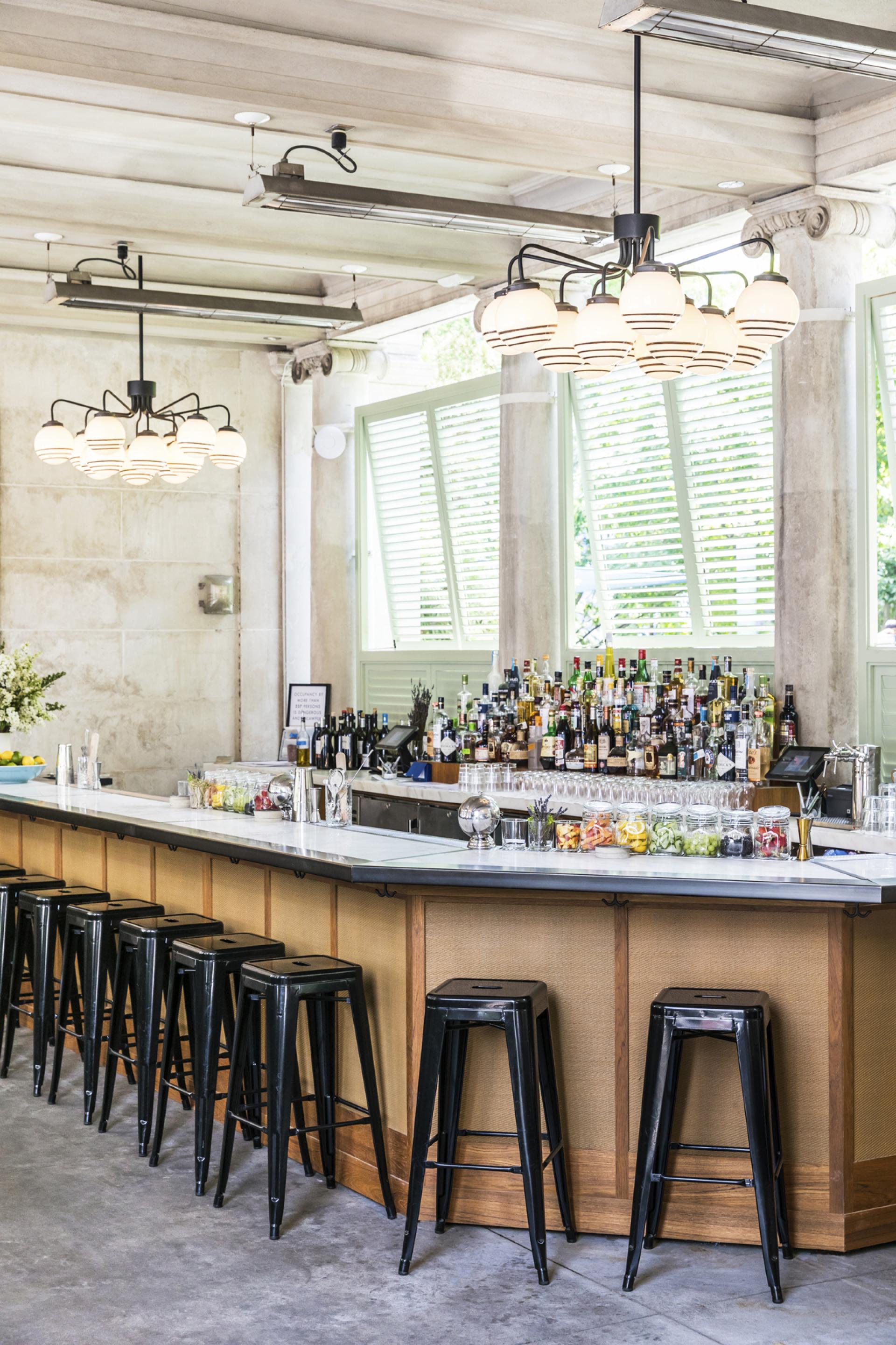 Stylish bar interior at Bocce in Union Square, featuring a sleek counter, modern lighting, and colorful cocktail ingredients.