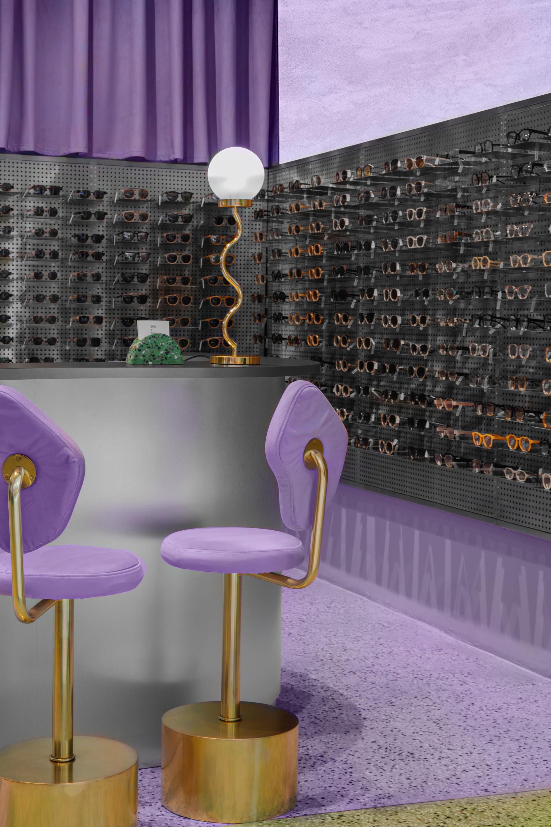Modern eyewear display featuring Breathe sunglasses, with stylish purple seating and contemporary decor elements.
