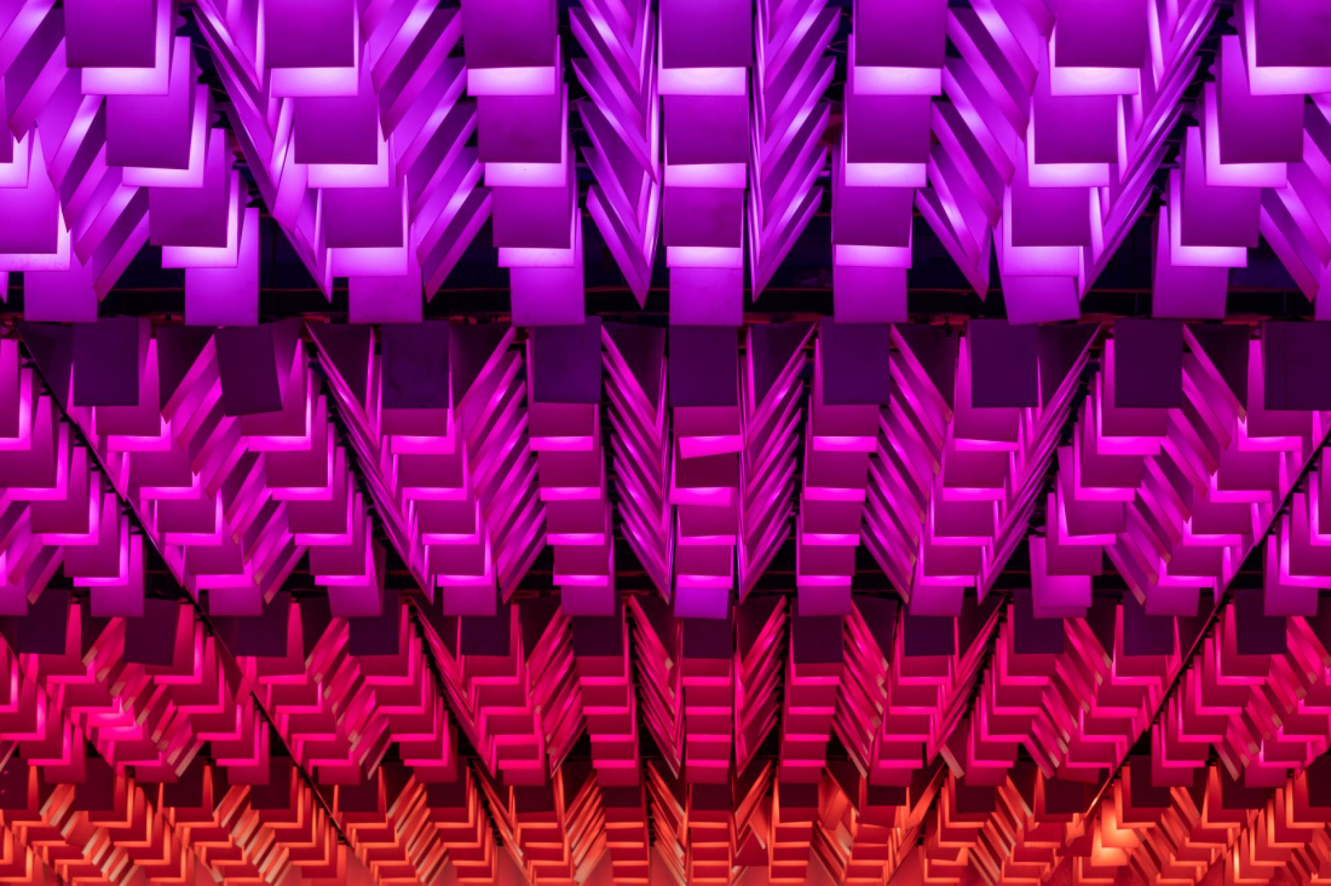 Colorful modern ceiling design featuring layered geometric shapes in shades of purple and pink, highlighting innovative architecture trends.