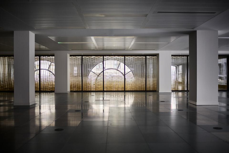 Interior view of Giles Miller's The Veil, showcasing thousands of brass louvres with unique patterns and reflections.