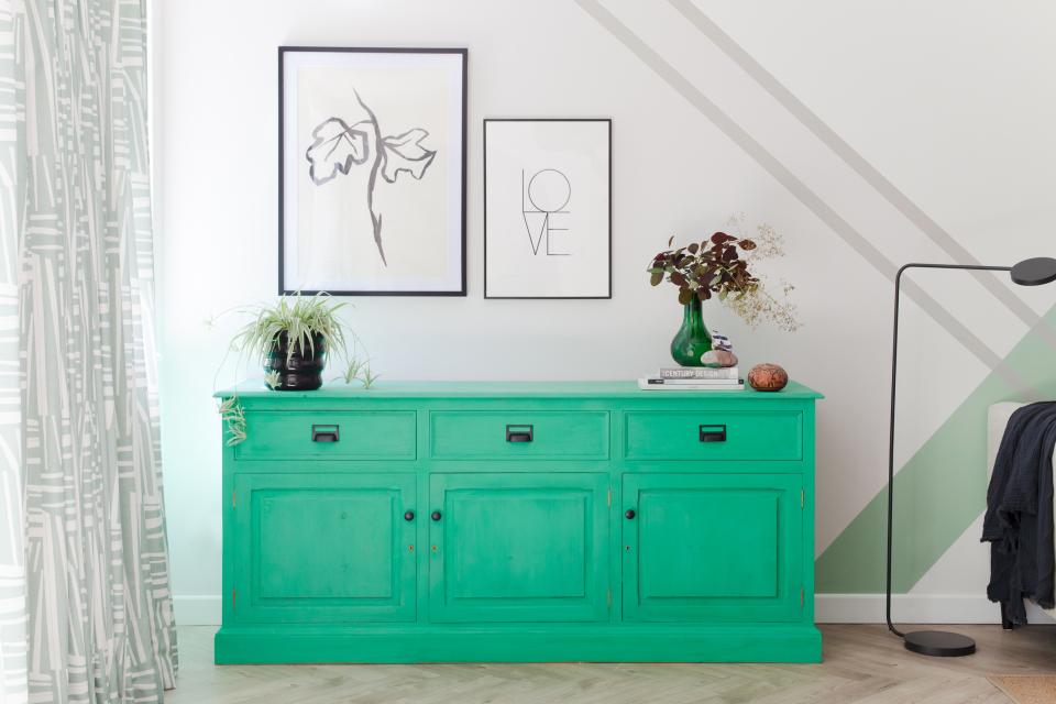 Bright green sideboard with art prints and decorative plants in a stylish Scandi Industrial family home interior.