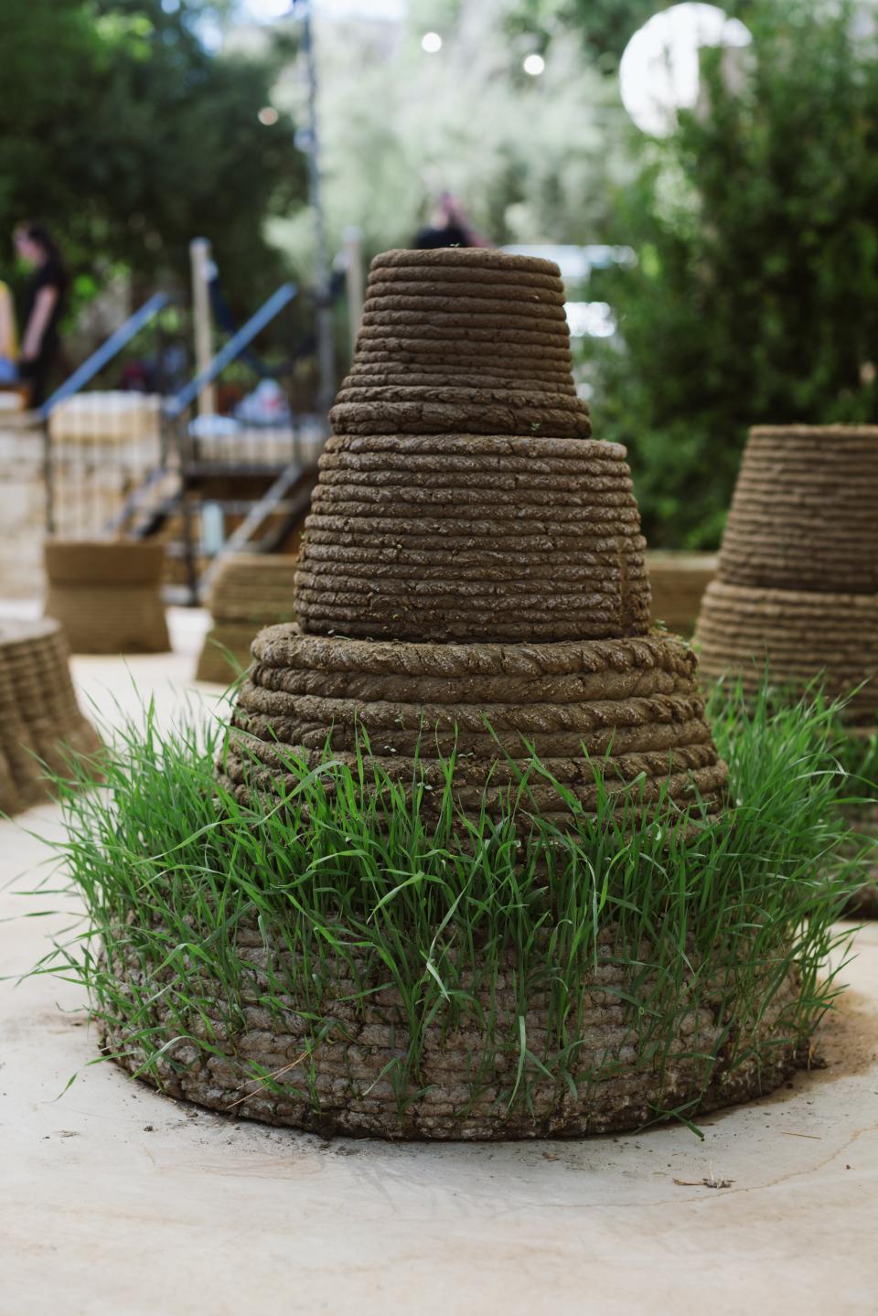 3D-printed earth structure featuring grass, displayed at Jerusalem Design Week 2022, showcasing innovative building techniques.