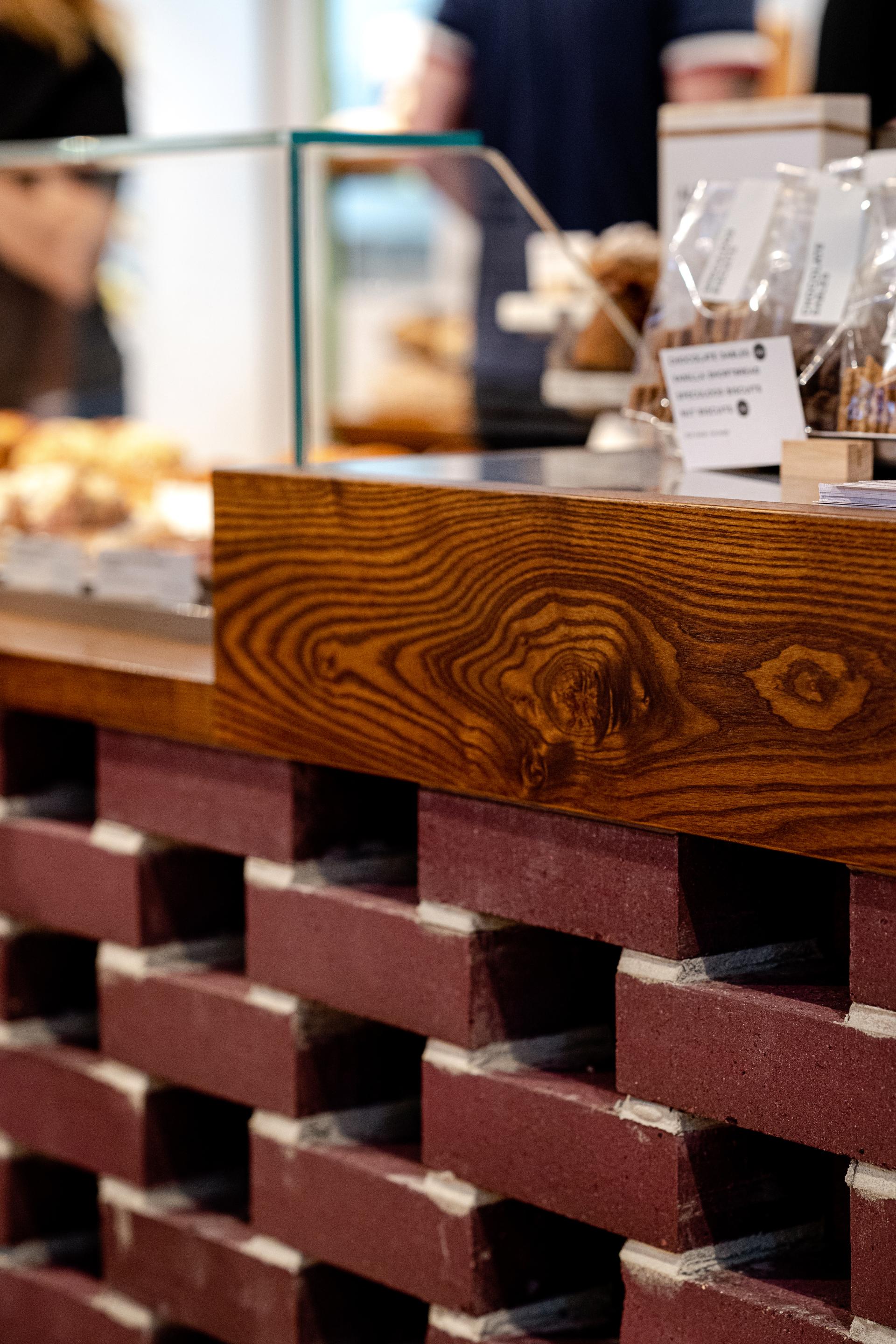 Close-up of a wooden counter featuring K-BRIQ's un-fired, ultra low carbon bricks, highlighting sustainable construction materials.