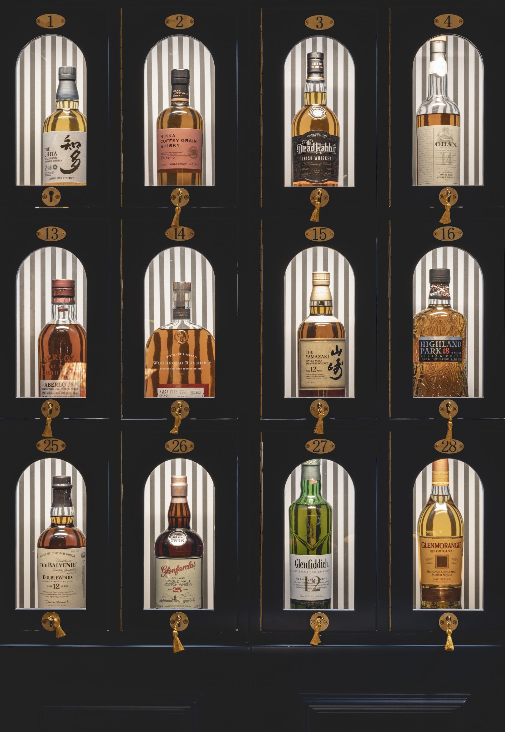 Whiskey bottles arranged in glass display cabinets at The Libertine, a new hospitality venue in London's Royal Exchange.