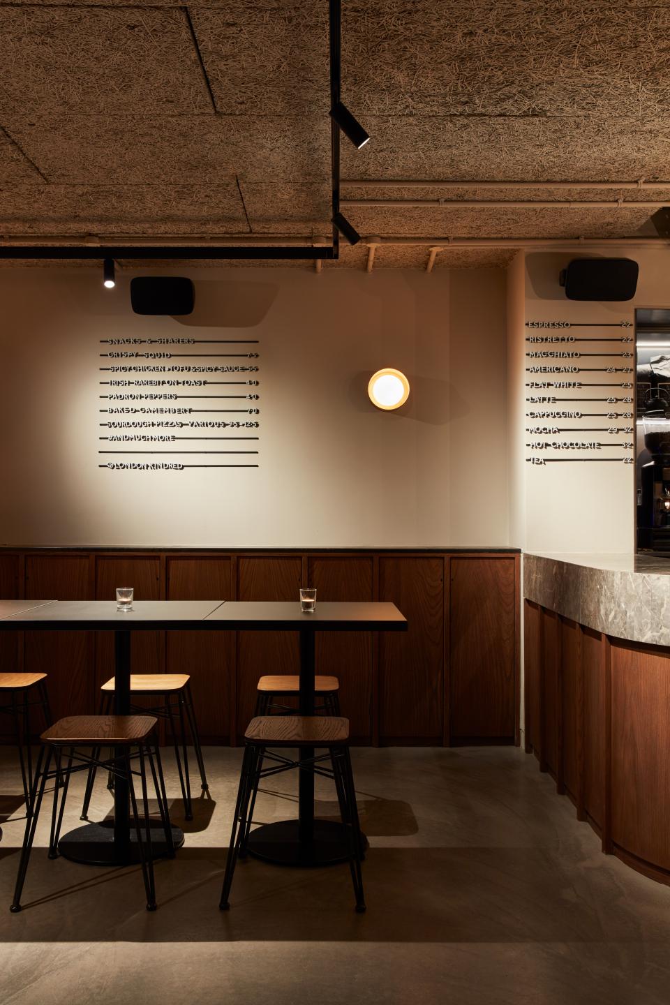 Stylish co-working space inspired by cocktail bars, featuring elegant furniture and a minimalist ambiance in central London.