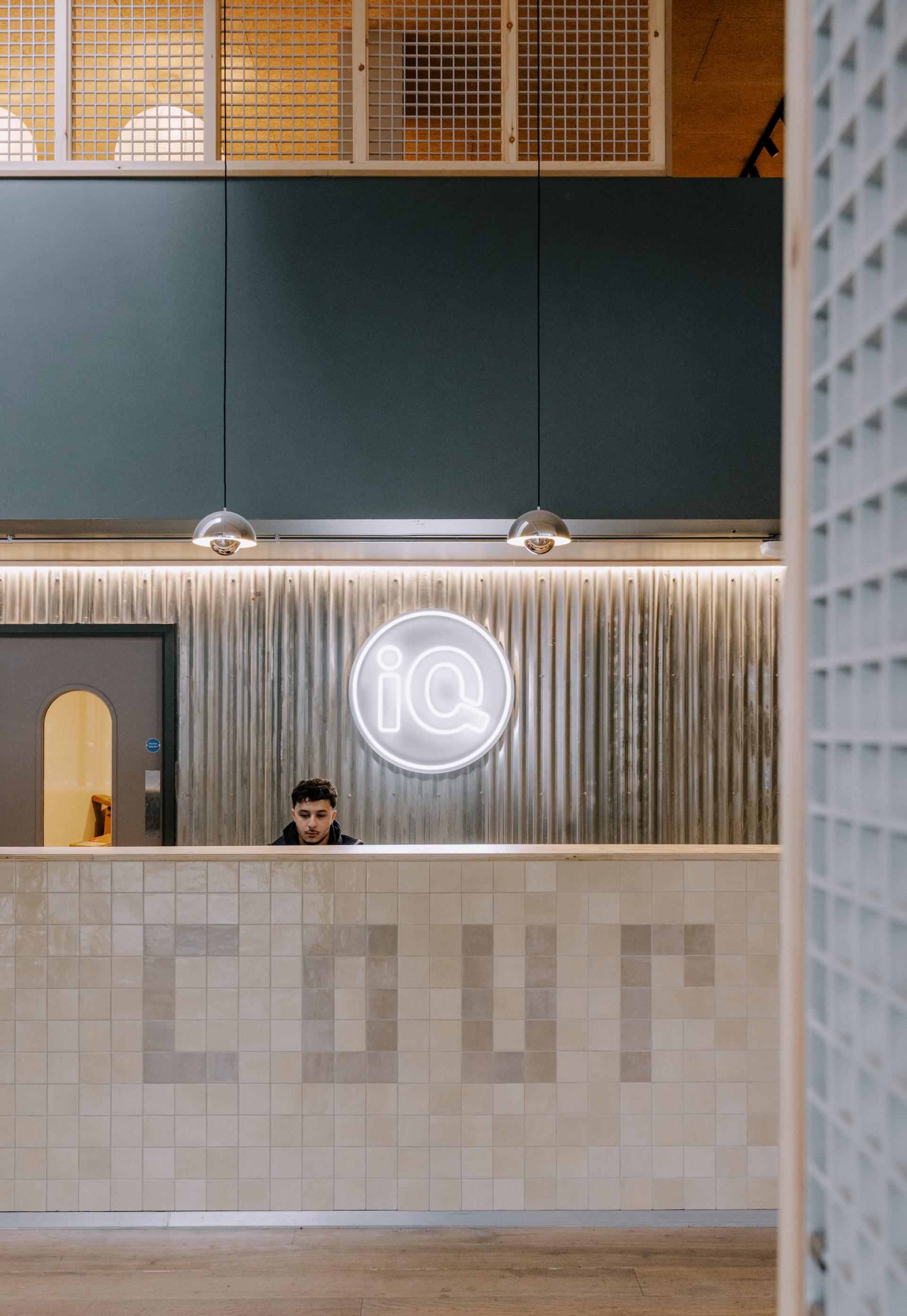 Modern reception area at iQ East Court, featuring stylish design and a sign inspired by Mile End's historic streets.