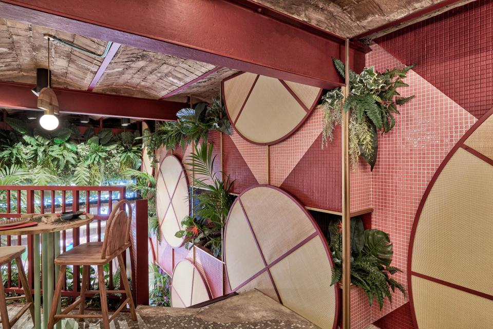 Vibrant interior design of Kaikaya, featuring lush greenery, circular patterns, and tropical elements, designed by Masquespacio.