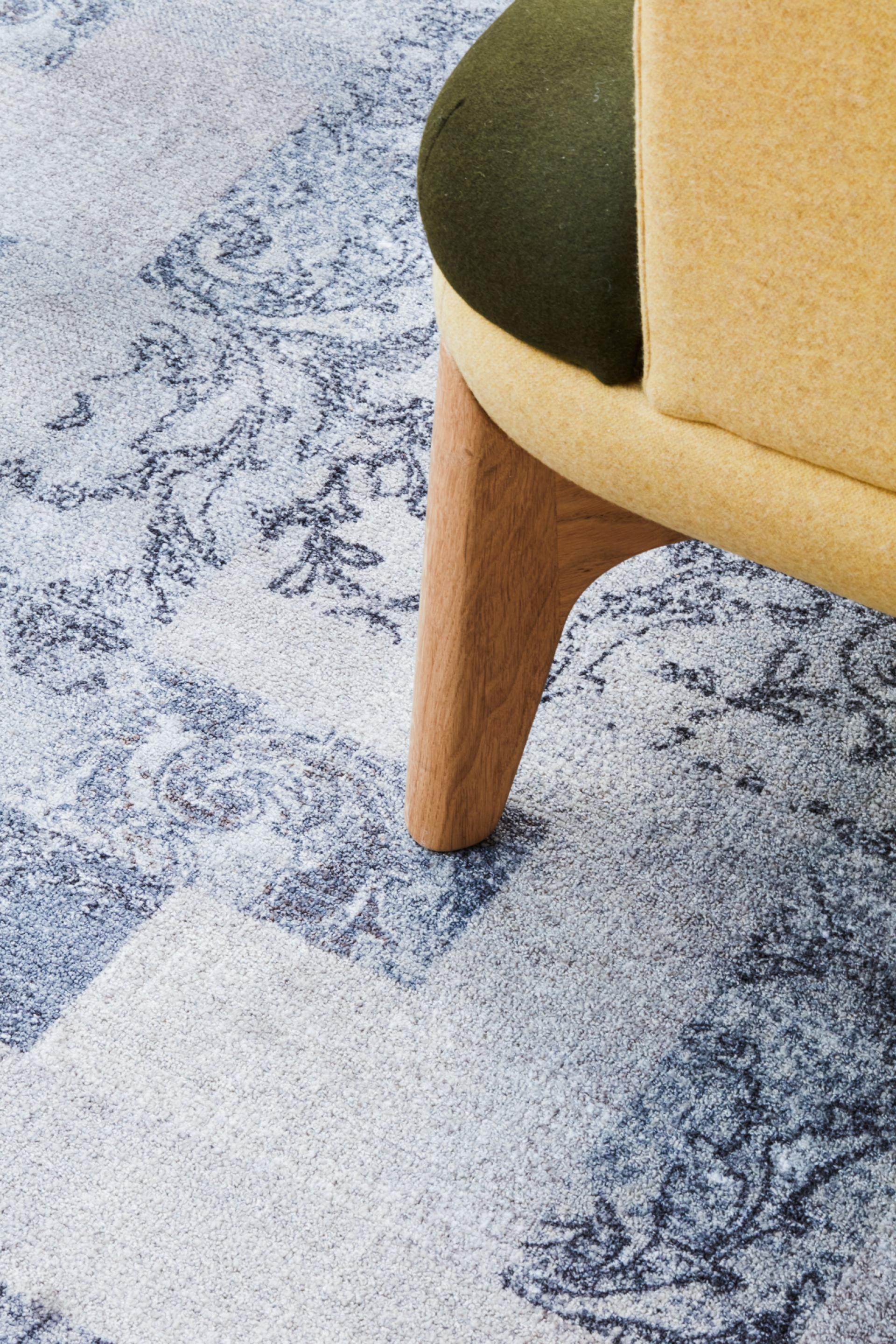 Modern seating with yellow and green upholstery on patterned carpet, reflecting innovative workspace design at Queen Mary University.