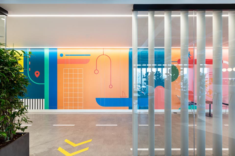 Vibrant office interior featuring colorful abstract murals and modern design elements, highlighting Modus' creative workspace for Travelfusion.