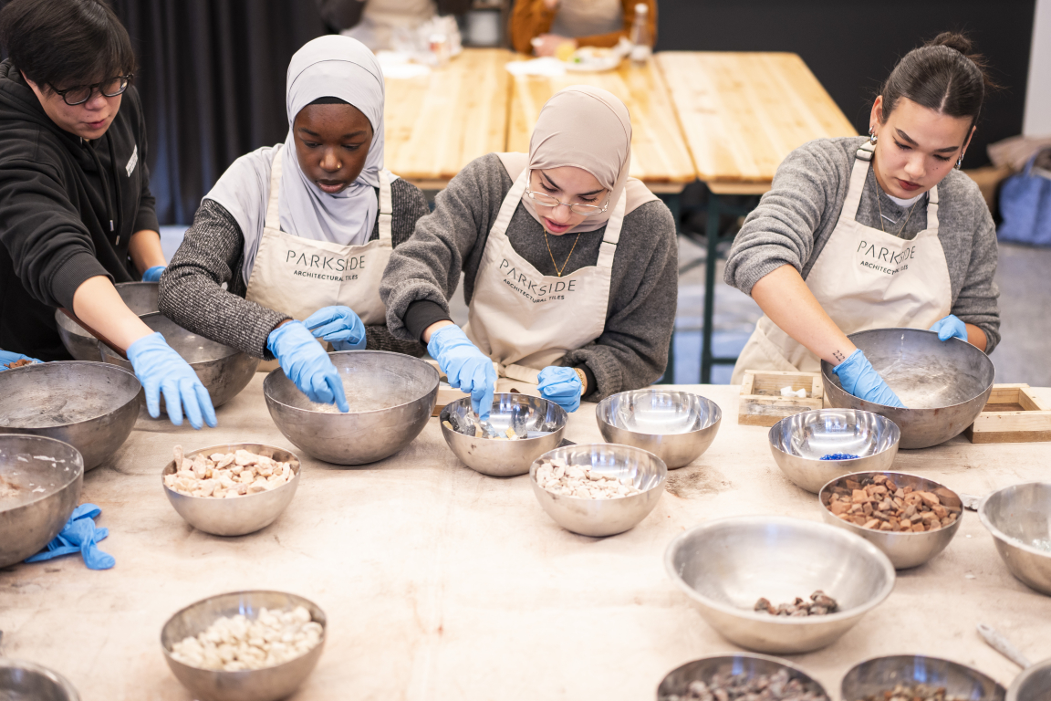 Participants engaging in a creative workshop at Material Source Studio, working with bowls of various materials.