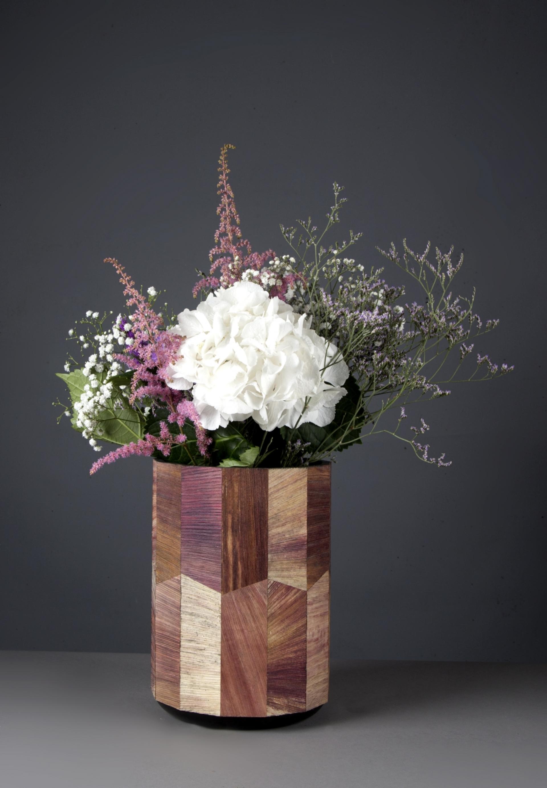 Sustainable wooden vase filled with assorted flowers, highlighting eco-friendly design concepts at the London Design Festival 2018.