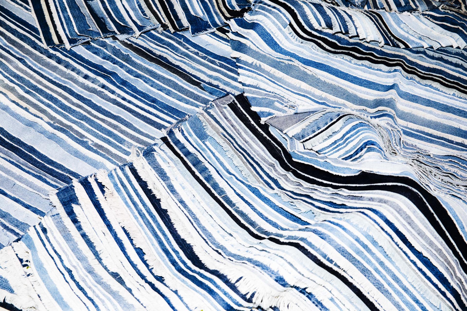 Textile featuring a vibrant mix of blue and white stripes, showcasing innovative design by contemporary independent designers at the London Design Fair.