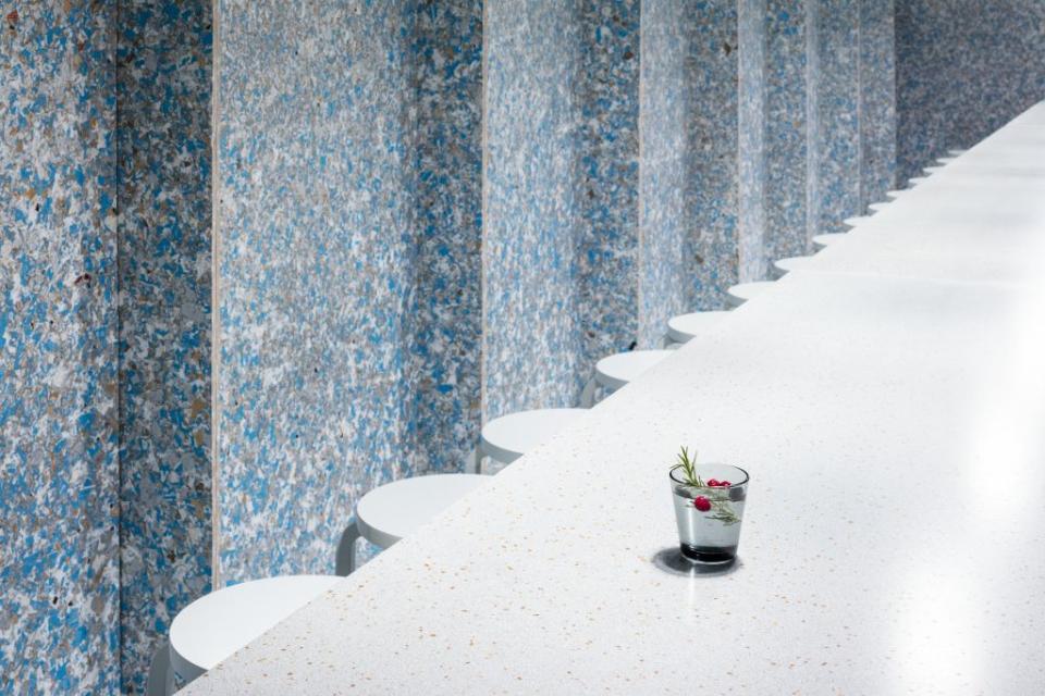 Stylish bistro interior featuring a sustainable design, with a cocktail placed on a sleek countertop.