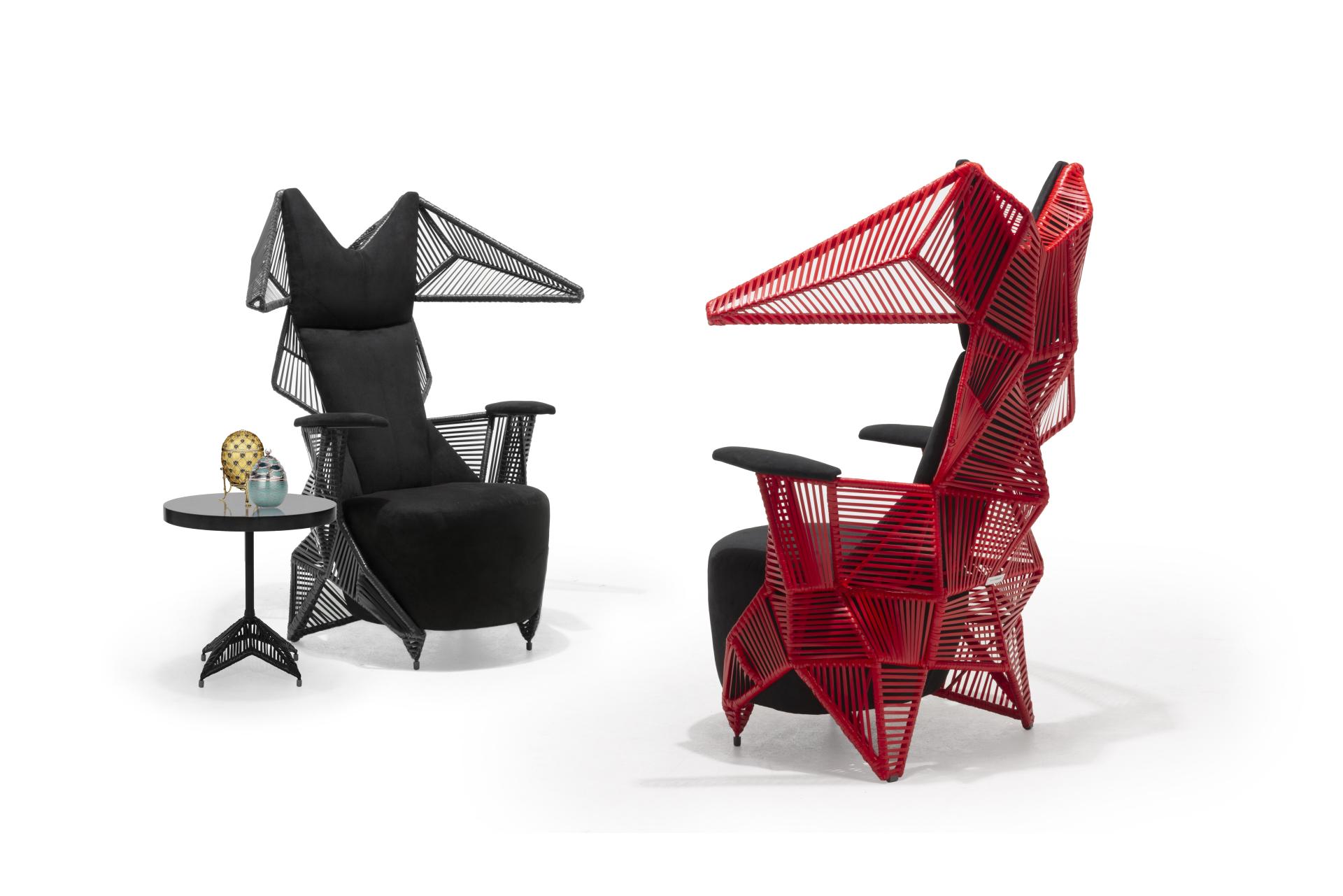 Stylish armchairs by Kenneth Cobonpue, featuring intricate designs in black and red, with a side table and decor.