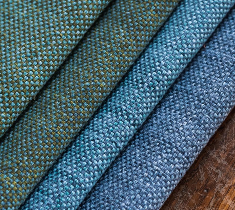 Upholstery fabric samples from Agua's VerdEco collection, showcasing textures and colors made from 100% upcycled textile waste.