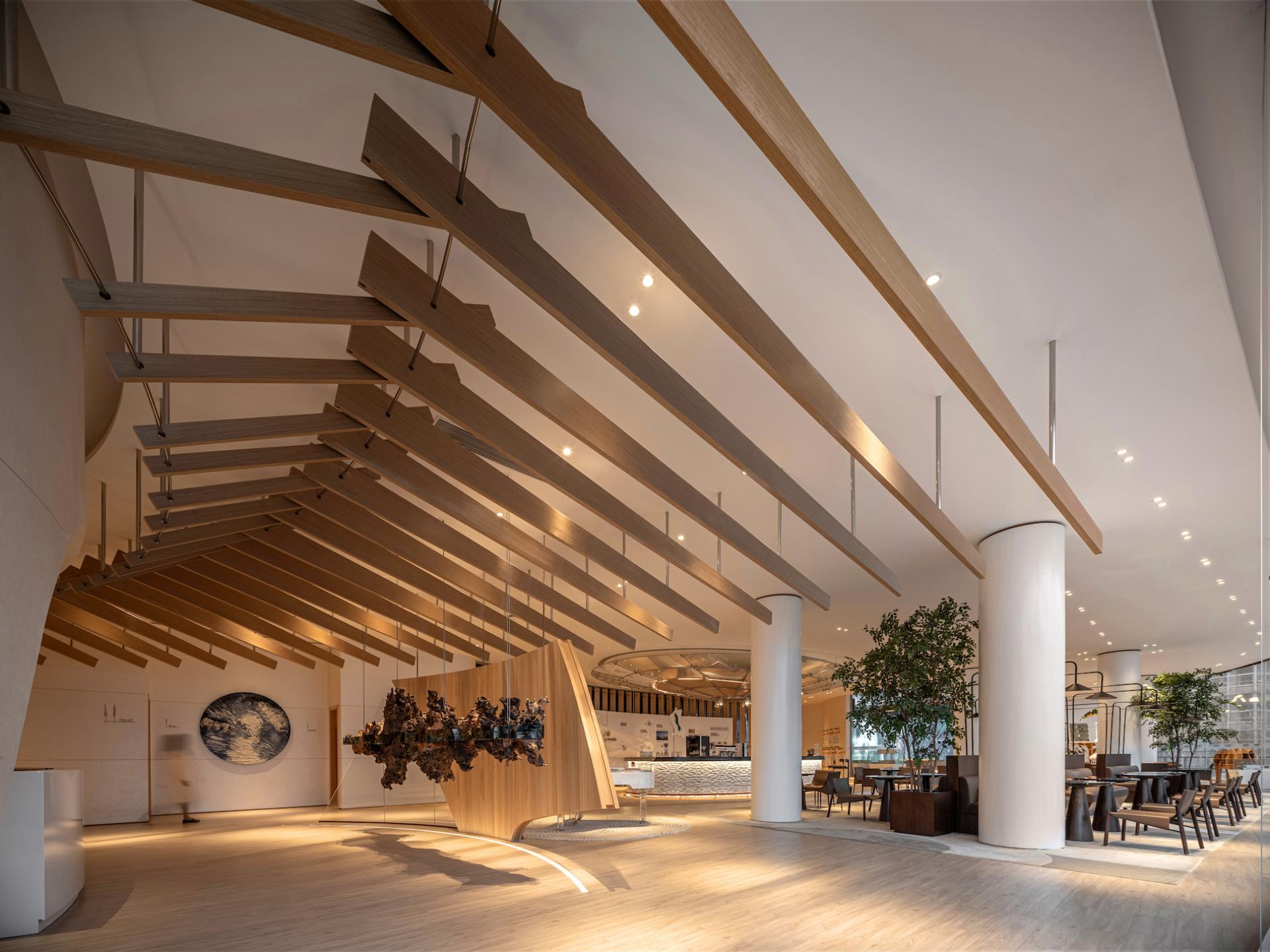 Lush greenery and innovative wooden beams define Karv One's modern exhibition hall interior in Dali, China.