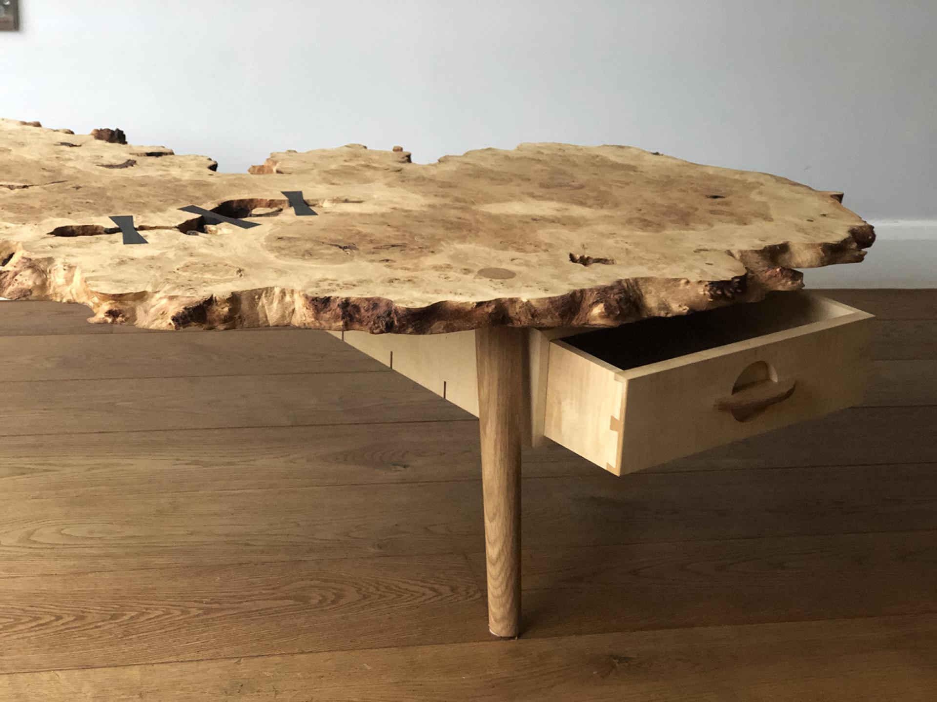 Elegant wooden table with a unique live edge design and a subtle drawer, showcasing craftsmanship inspired by Japanese aesthetics.