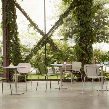 Cozy outdoor dining area surrounded by lush greenery, showcasing a harmonious blend of nature and modern design.