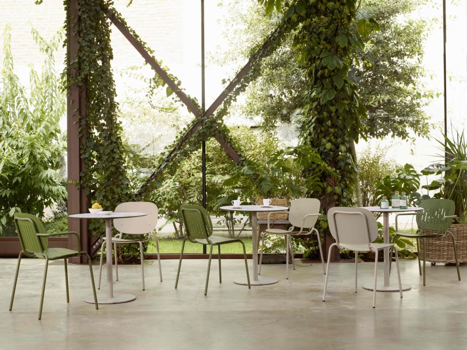 Cozy outdoor dining area surrounded by lush greenery, showcasing a harmonious blend of nature and modern design.