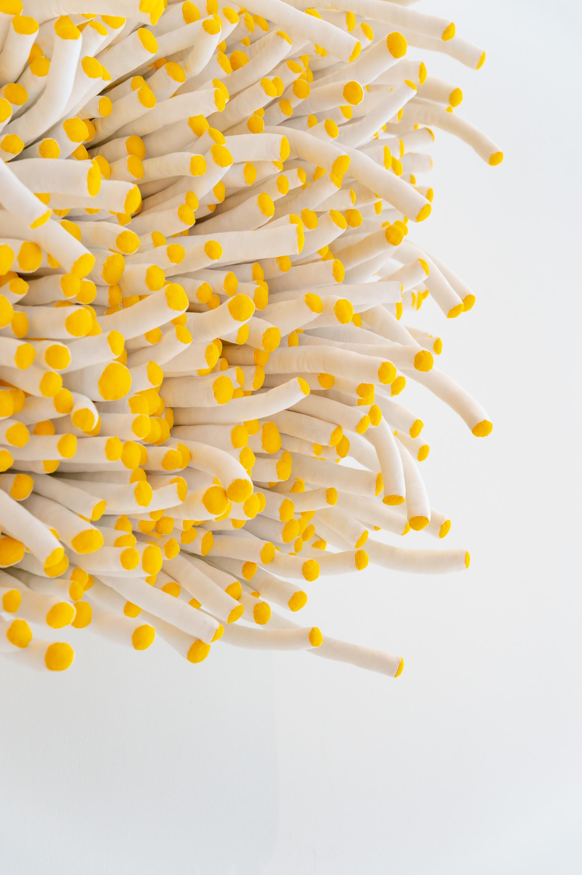Textile art installation by Anna Ray, featuring white fabric tubes with bright yellow tips, highlighting London's weaving heritage.
