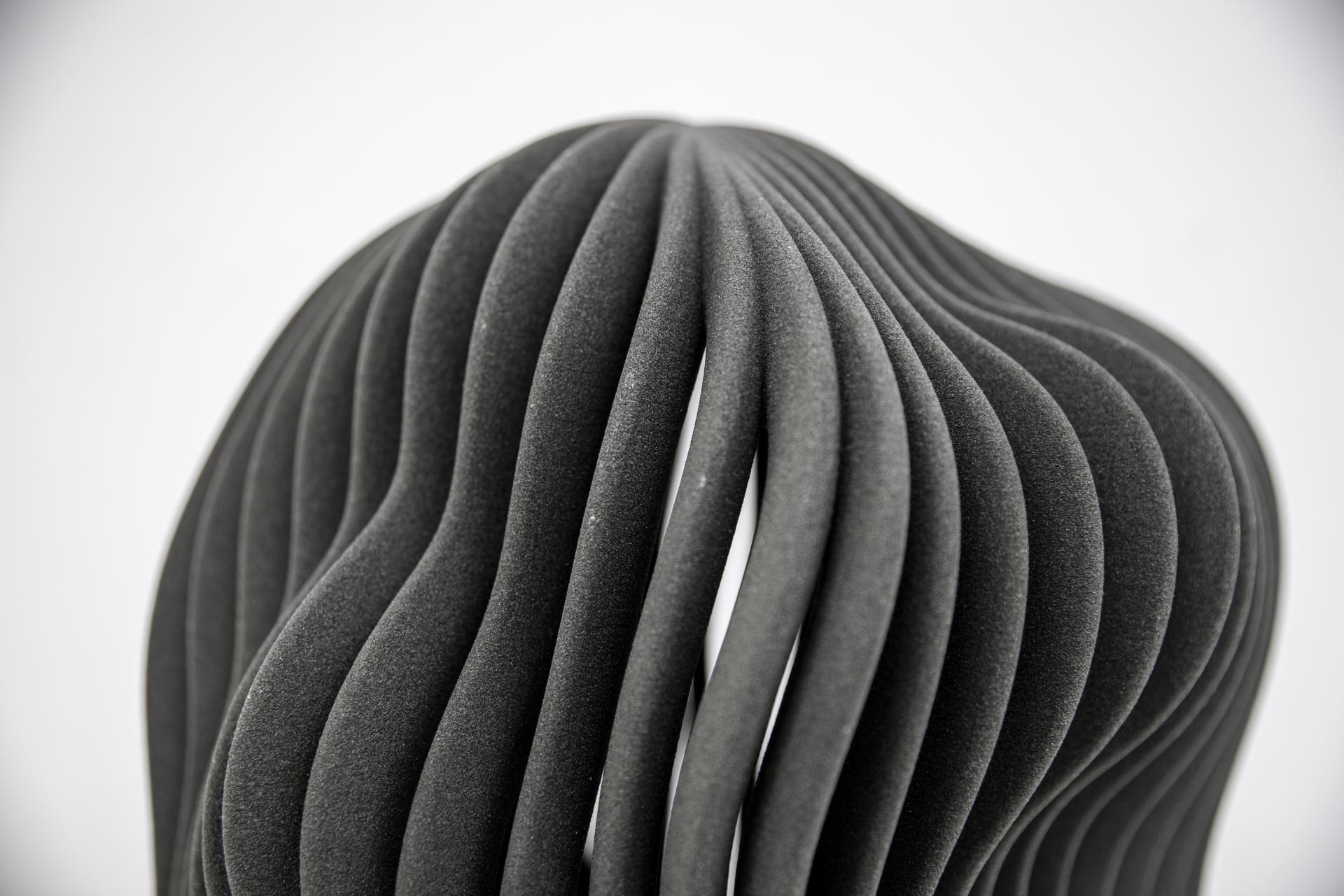 Stylish black 3D printed sculpture showcasing innovative design, highlighting the potential of modern 3D printing techniques.