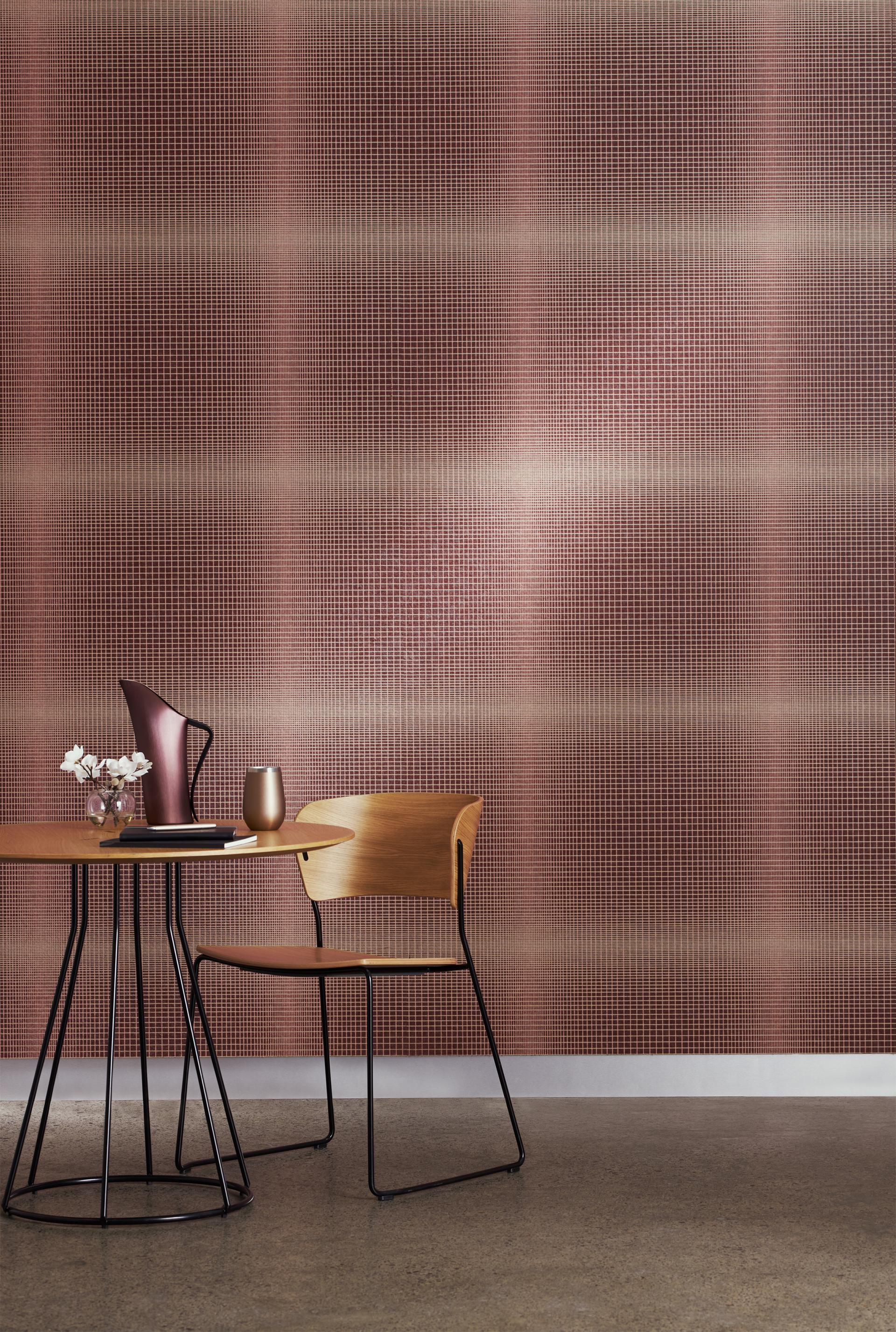 Elegant plaid wallpaper in warm tones adorns the wall behind a minimalist wooden table and chair setup.
