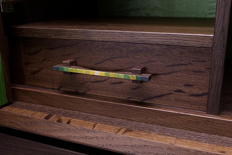 Intricately designed cabinet drawer featuring a colorful, decorative handle by furniture maker Kevin Stamper, inspired by Madeira.