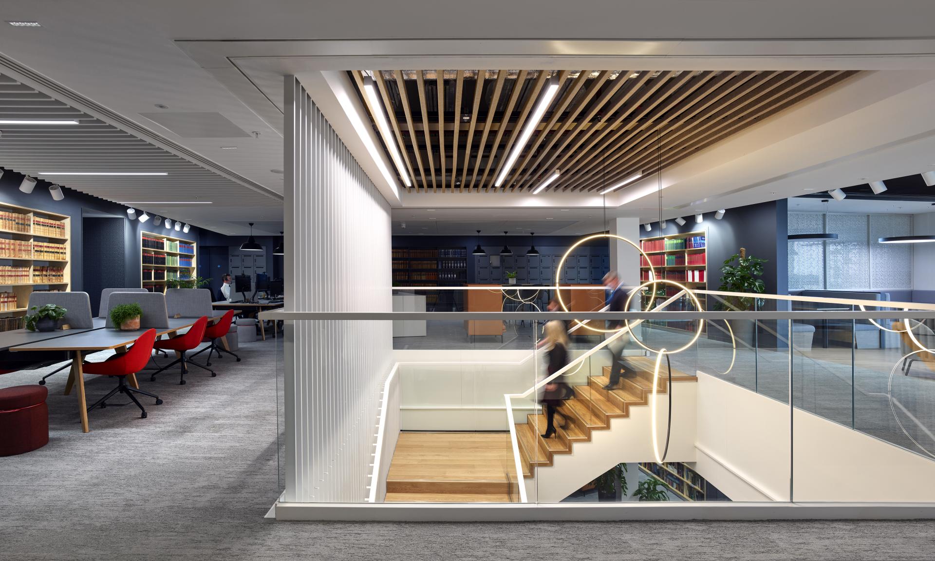 Modern office interior of Michael Laird Architects in Manchester, featuring open workspace, vibrant decor, and staircase.