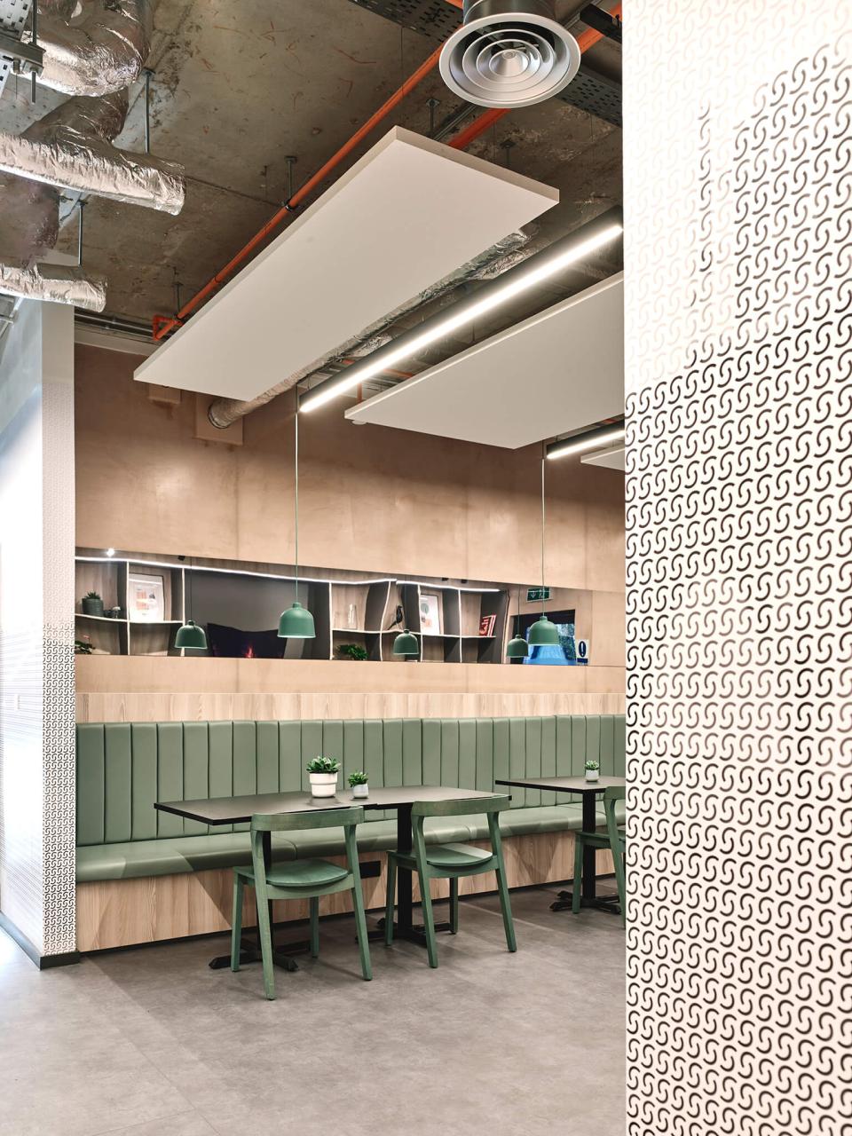 Modern dining area in The Tannery student living space, featuring green seating and stylish lighting in Leicester.