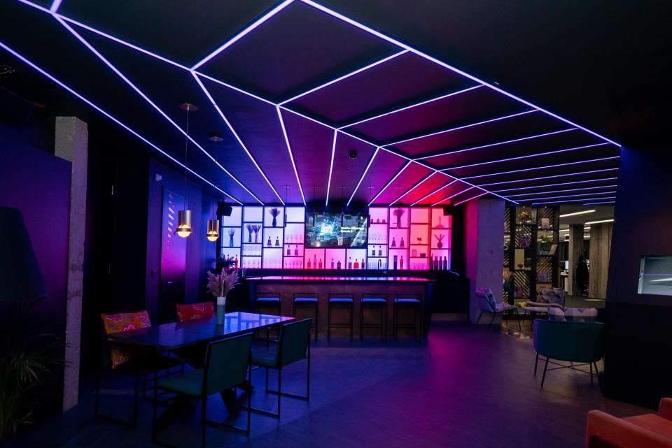 Modern bar interior featuring dynamic lighting and colorful backlit shelves at the Pixel Artworks London showroom.