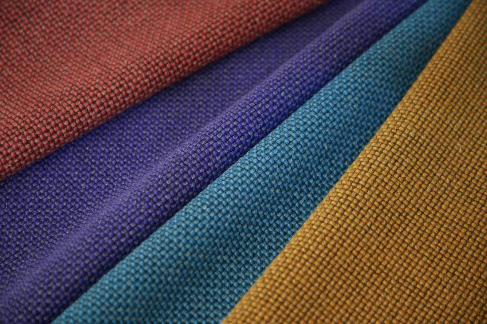 Vibrant swatches of Camira's Craggan Flax fabric showcasing sustainable, textured textiles in rich colors.