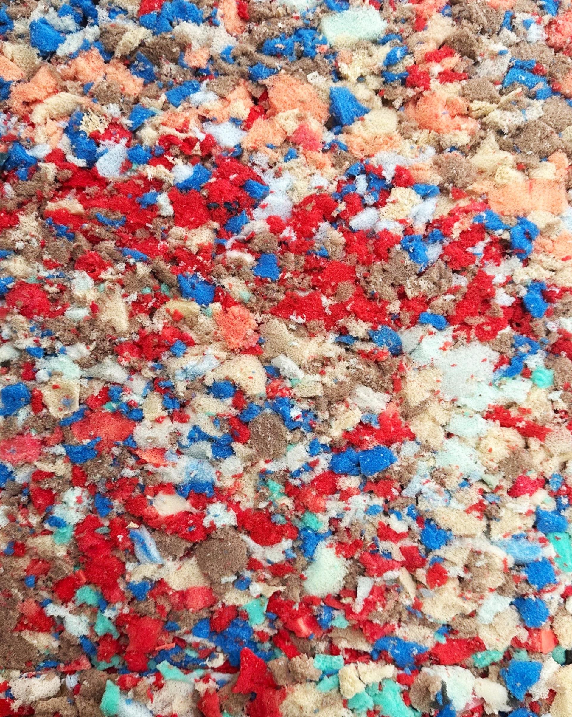 Colorful, recycled polyurethane foam pieces in various shades, representing eco-friendly materials for sustainable construction.