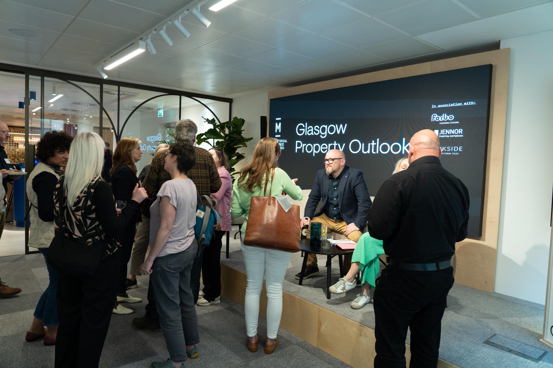 Gathering of attendees discussing Glasgow’s property outlook at a presentation event, showcasing industry insights and engagement.