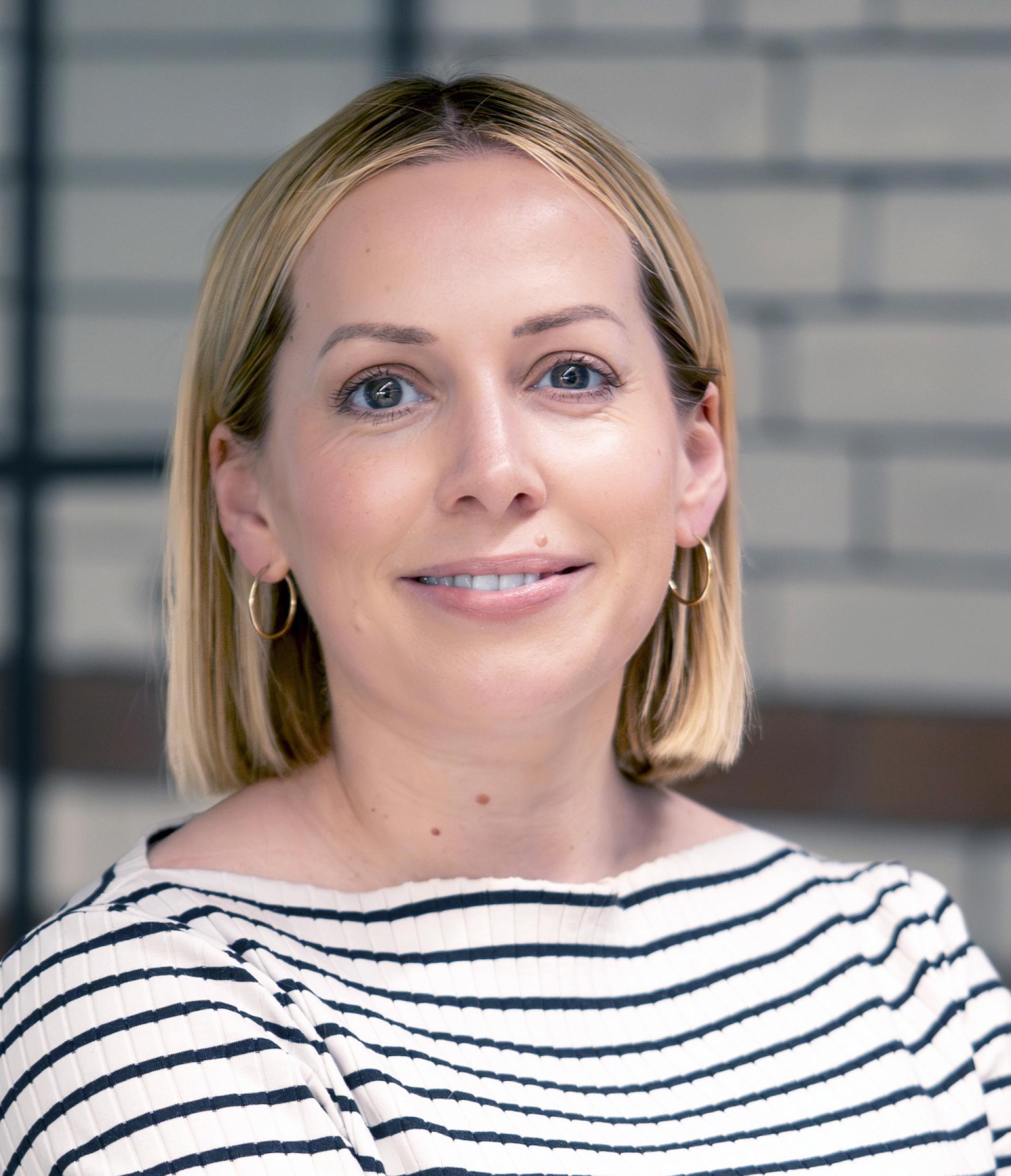 Manchester property expert smiling, representing discussions on the city's residential mix and property outlook.