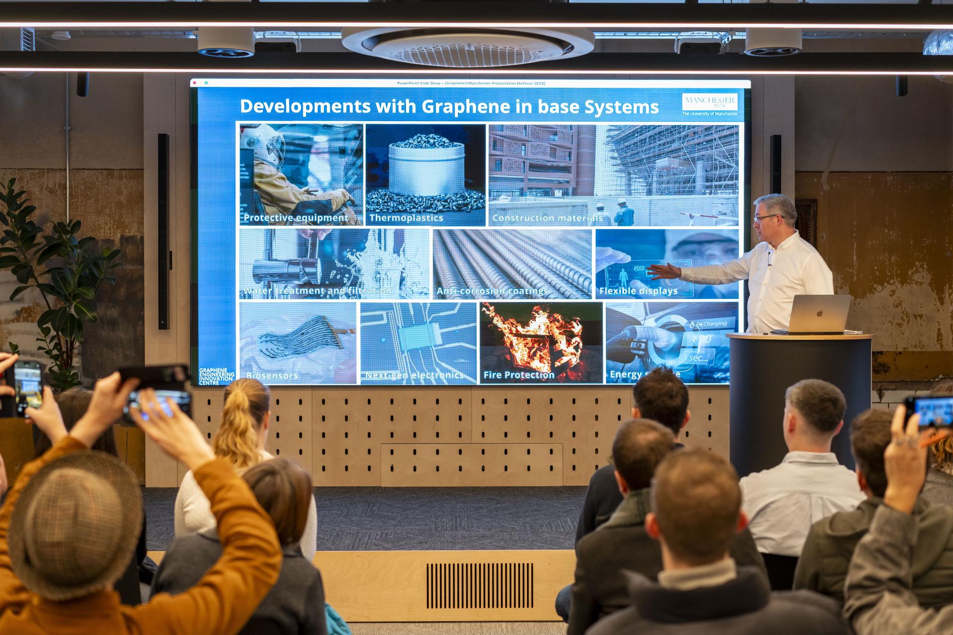 John Whittaker presenting developments in graphene applications, including construction materials and protective equipment, to an engaged audience.