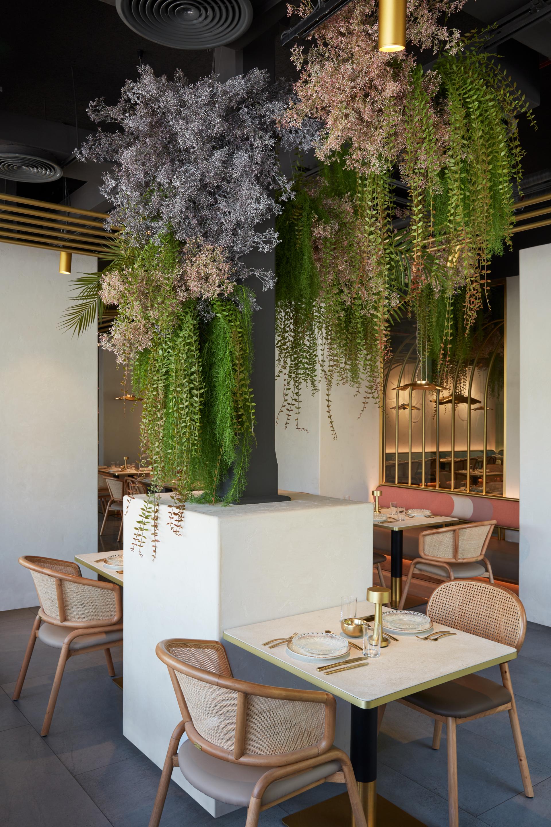 Contemporary dining area at Mezza House featuring lush greenery, elegant decor, and stylish furniture by Roar Design Studio.