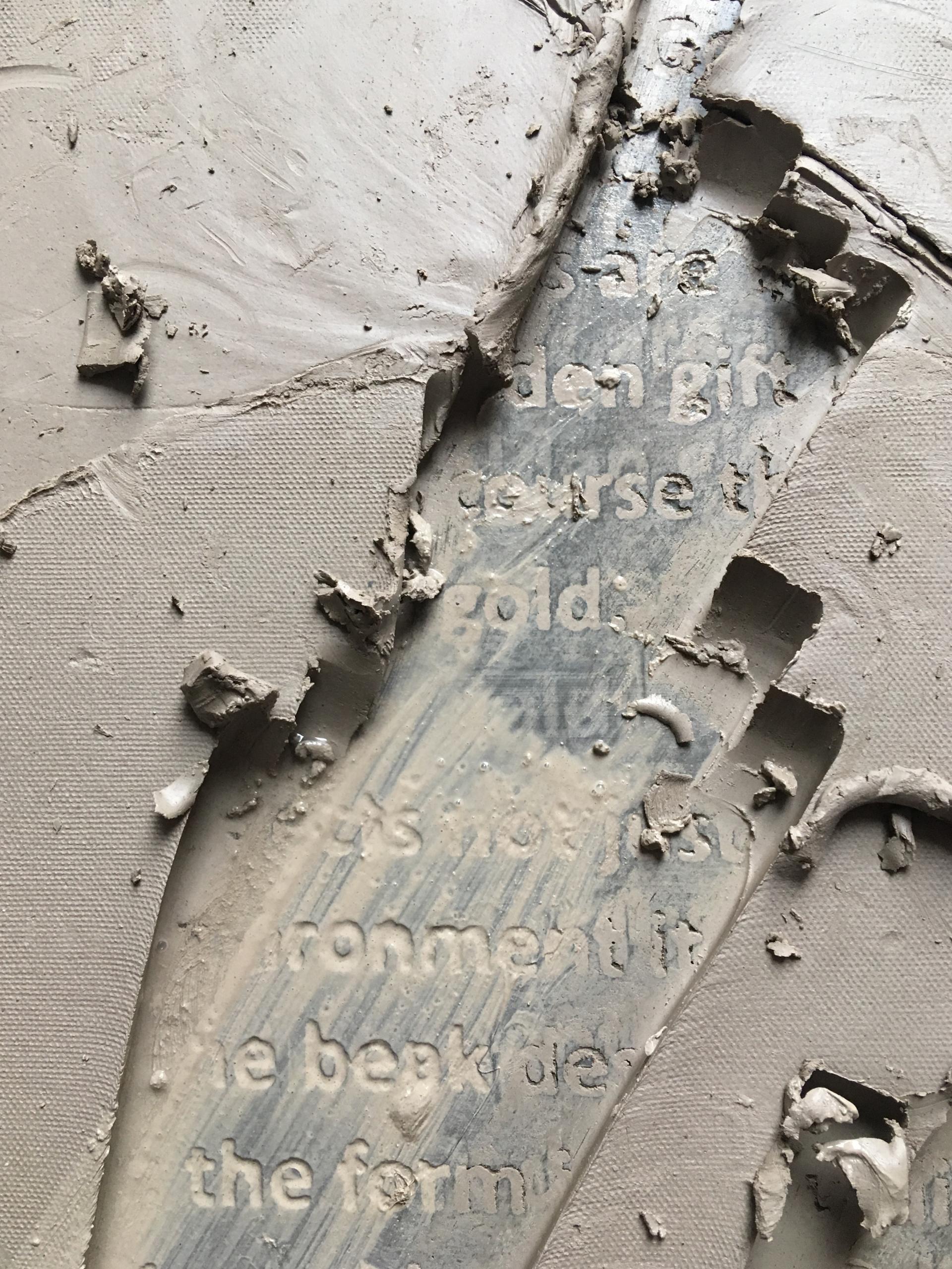 Textured clay surface with visible lettering, showcasing material experimentation in design by May Wild Studio.